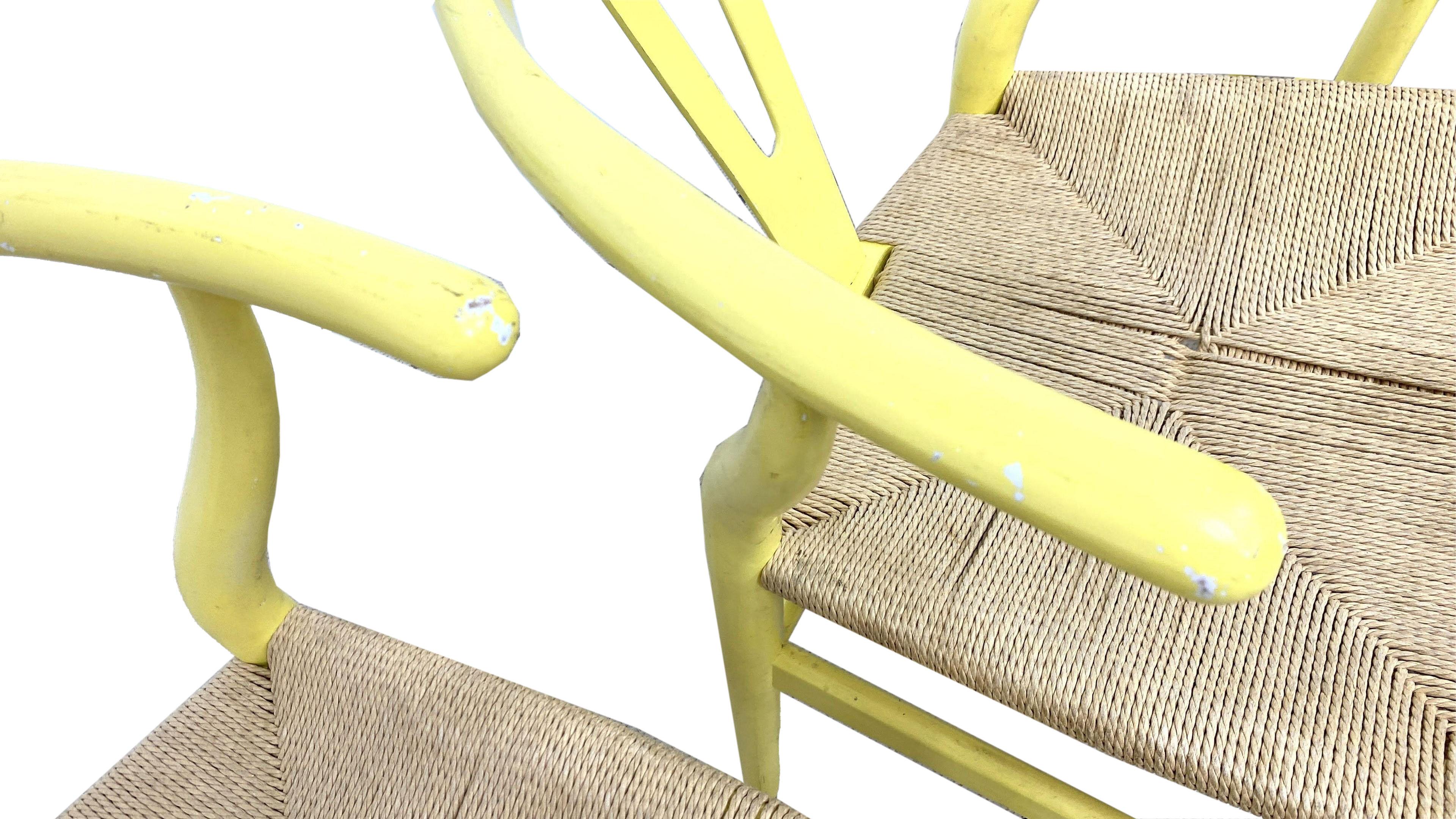 These wishbone chairs are painted in a wonderful yellow with rush seats.

In 1944, Danish designer Hans Wegner began a series of chairs that were inspired by portraits of Danish merchants sitting in Ming chairs. One of these chairs was the