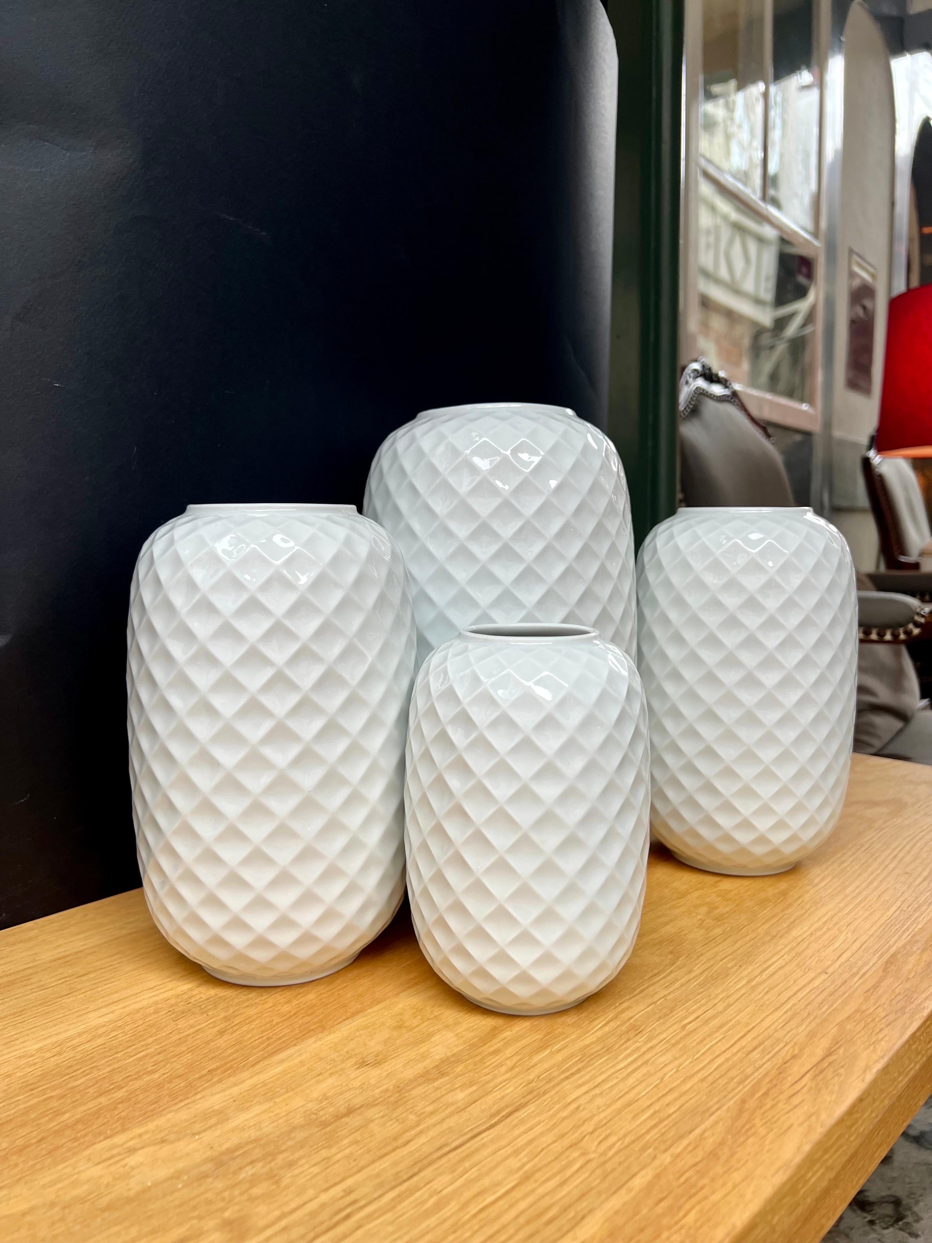 Mid-Century Modern / Op Art set of 4 glazed white porcelain vases from German manufacturer Thomas. This design belongs to their Holiday series, and came in production in the 1960. 

The beautifully rounded vases with its honeycomb / diamond