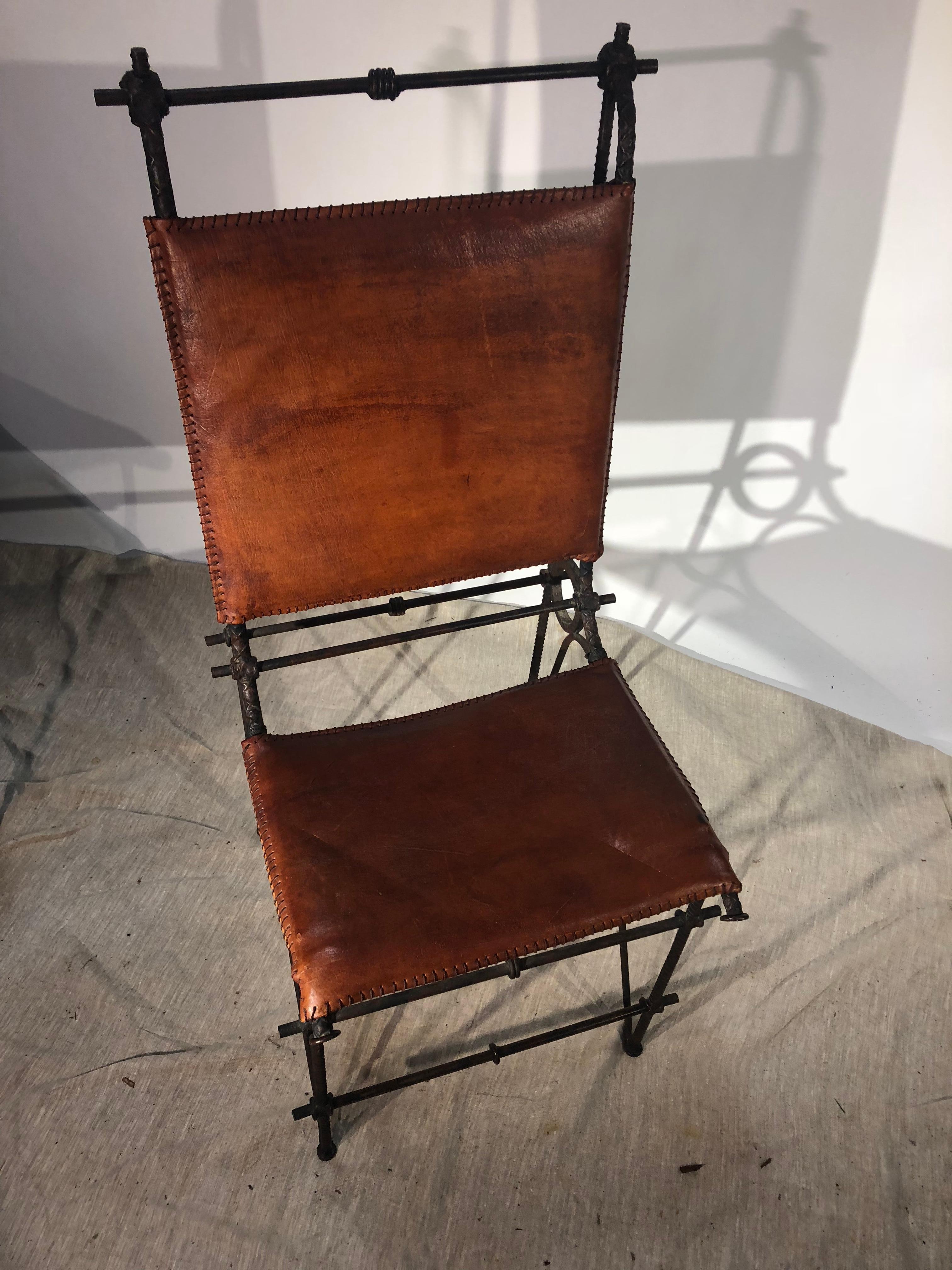 A set of 4 iron and saddle leather side chairs attributed to Ilana Goor, circa 1985. These interesting hand-crafter chairs are in the “Brutalist” style and are in good condition for their age and use.