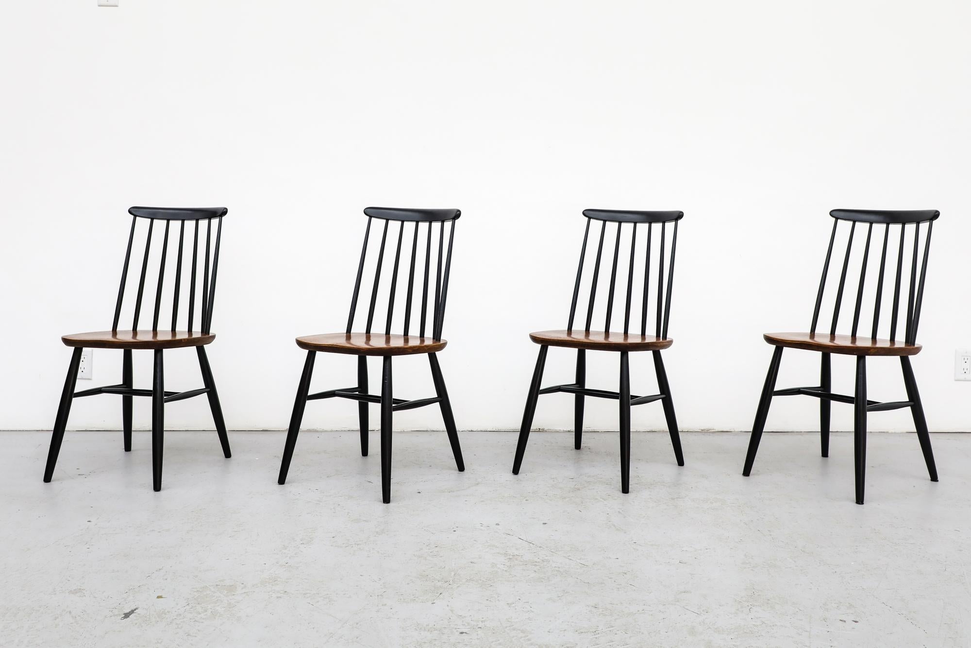 Set of 4 vintage Ilmari Tapiovaara inspired spindle back dining chairs with teak seats and black stained back and legs by Thomas Harlev for Farstrup. These chairs are in original condition with visible wear, consistent with their age and use. Other