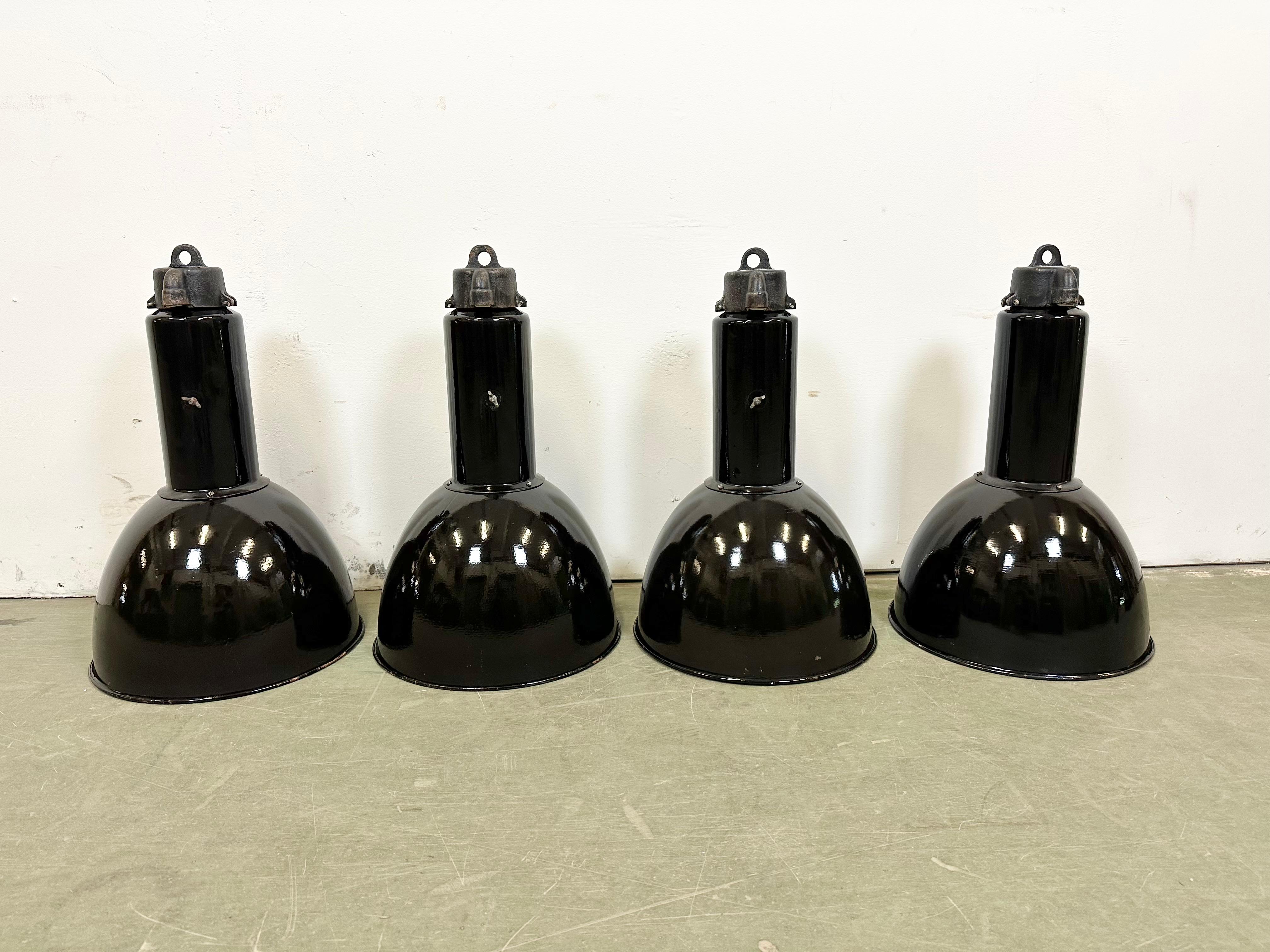 4 Industrial black enamel pendant lamps made by Elektrosvit in former Czechoslovakia in the 1960s. Designed during the 1930s,in the period of Bauhaus and produced till 1970s White enamel inside the shade. Cast iron top. New porcelain socket requires