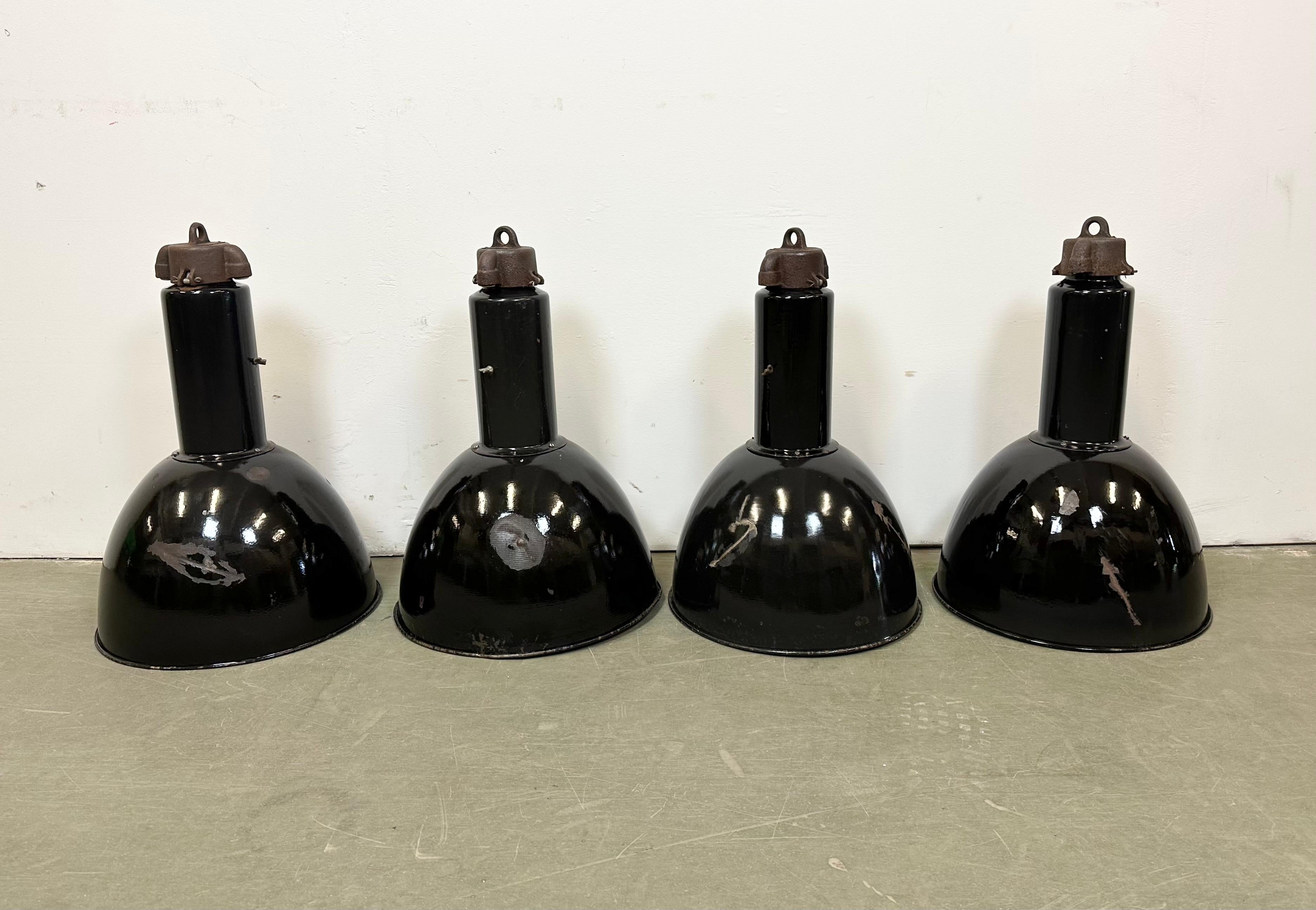 4 Industrial black enamel pendant lamps made by Elektrosvit in former Czechoslovakia in the 1950s. Designed during the 1930s,in the period of Bauhaus and produced till 1970s White enamel inside the shade. Cast iron top. New porcelain socket requires