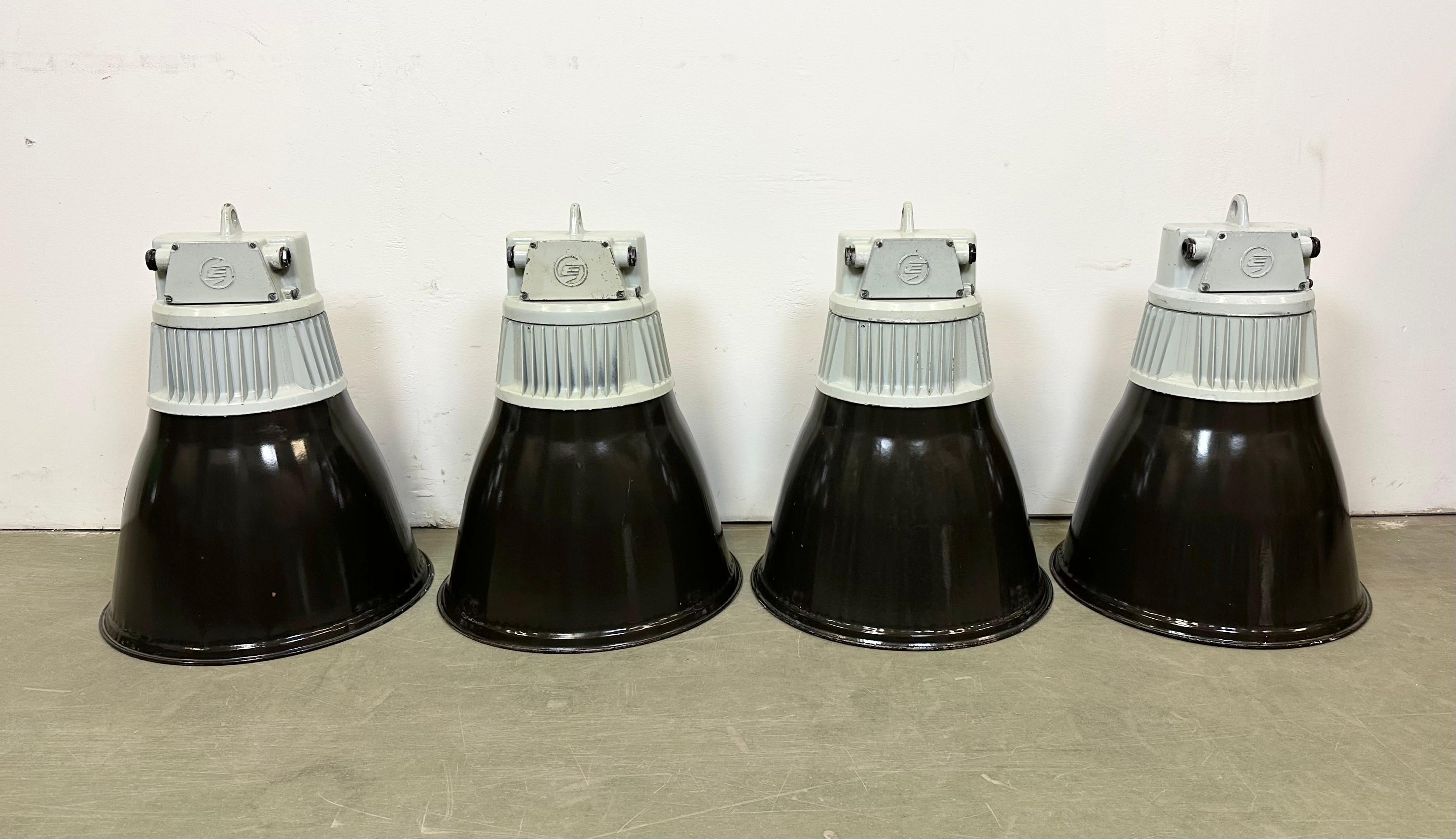 4 Industrial black enamel pendant lamps made by Elektrosvit in former Czechoslovakia during the 1970s . White enamel inside the shade. Cast aluminium top. New porcelain socket requires standard E 27/ E 26 lightbulbs. New wire.The weight of the lamp