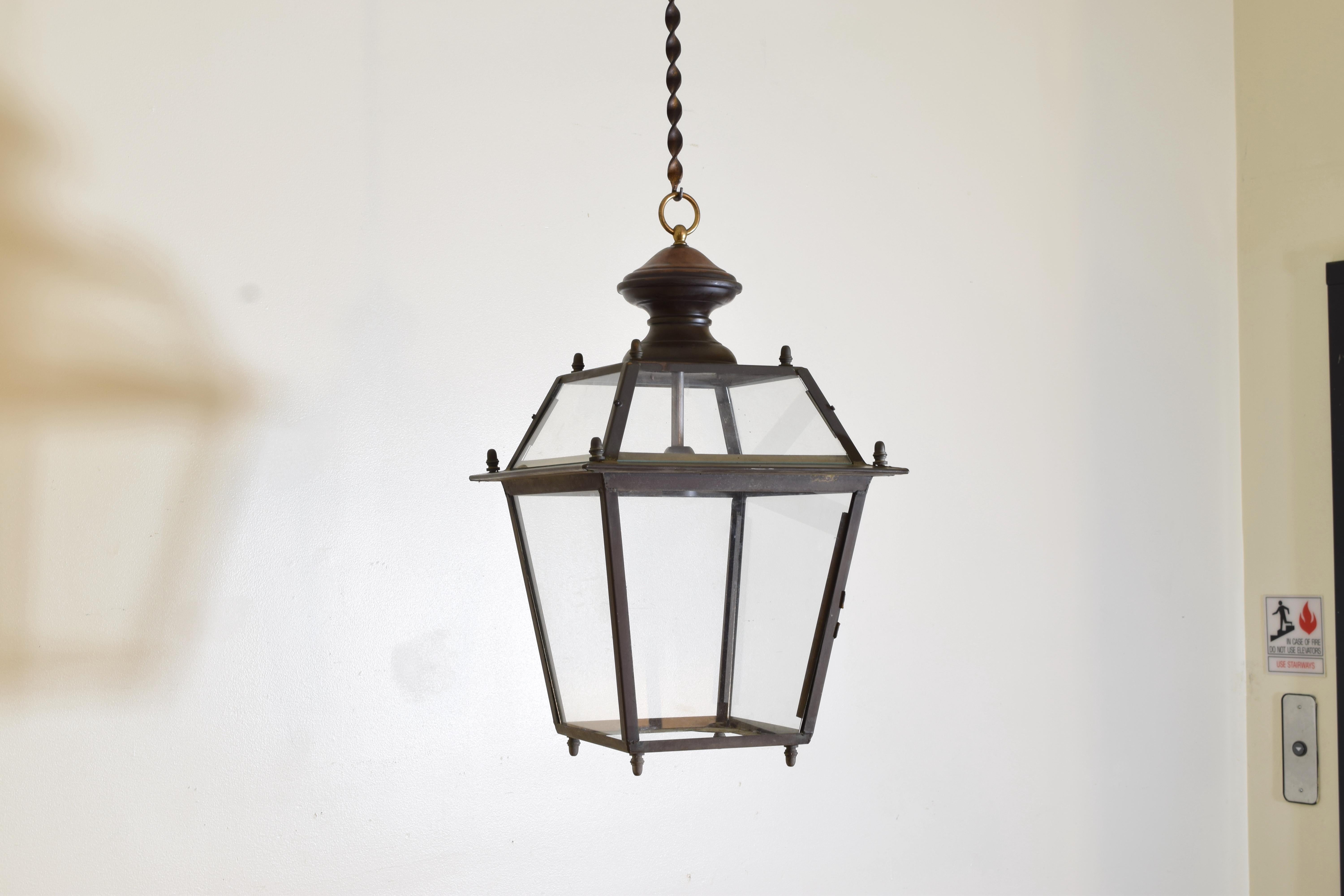 Constructed in the style of the Baroque, each lantern hanging from a brass ring atop a patinated copper cupola atop a patinated brass frame, the upper part of the frame with tapering sides enclosing glass panes, the lower part reverse tapering and