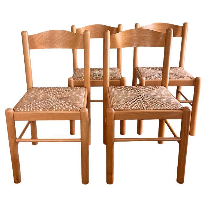 Un intramontabile set di quattro sedie da pranzo artigianali italiane, con struttura in legno naturale e sedute in giunco intrecciato a mano in un classico stile country italiano. Con il timbro 