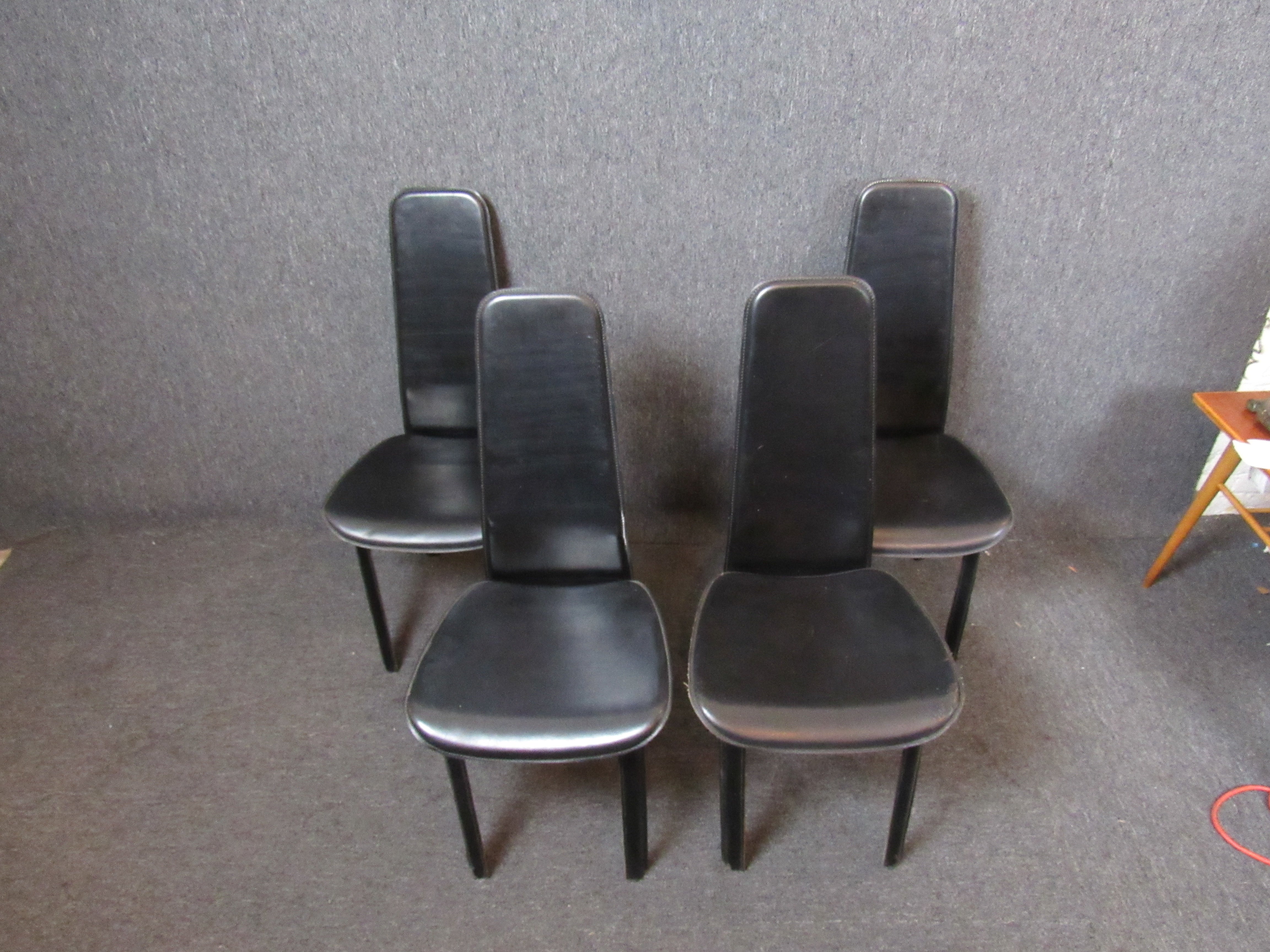 Stilvolles Set aus vier schwarzen Vinyl-Esszimmerstühlen aus der Mitte des Jahrhunderts von Cidue. Ein schlankes, vornehmes Profil, das jeder Küche oder jedem Esszimmer einen Hauch von Klasse verleiht. (Bitte bestätigen Sie den Standort des Artikels