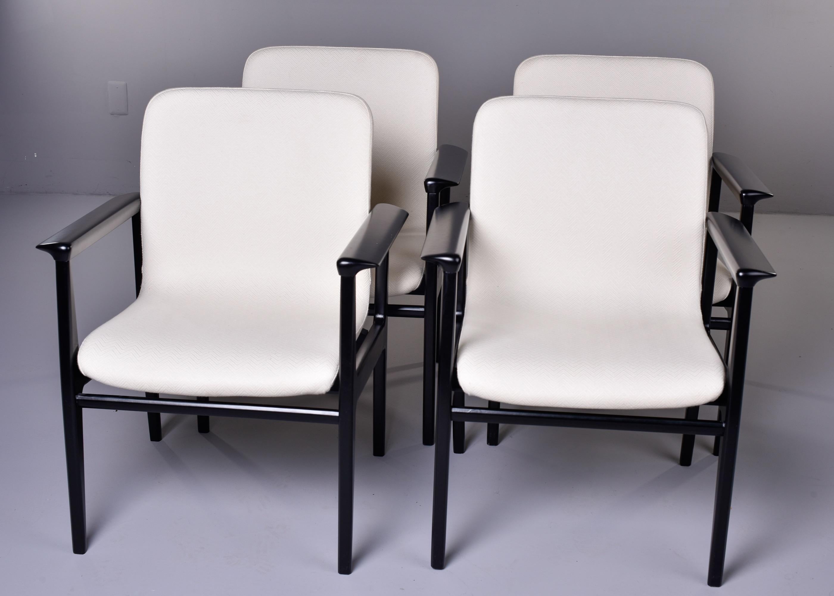 Found in Italy, this set of four circa 1970s armchairs feature black lacquered sleek wood frames with tapered legs and molded seats upholstered in a white, chevron pattern weave. Unknown maker. Sold and priced as a set of four. 

Measures: Arm