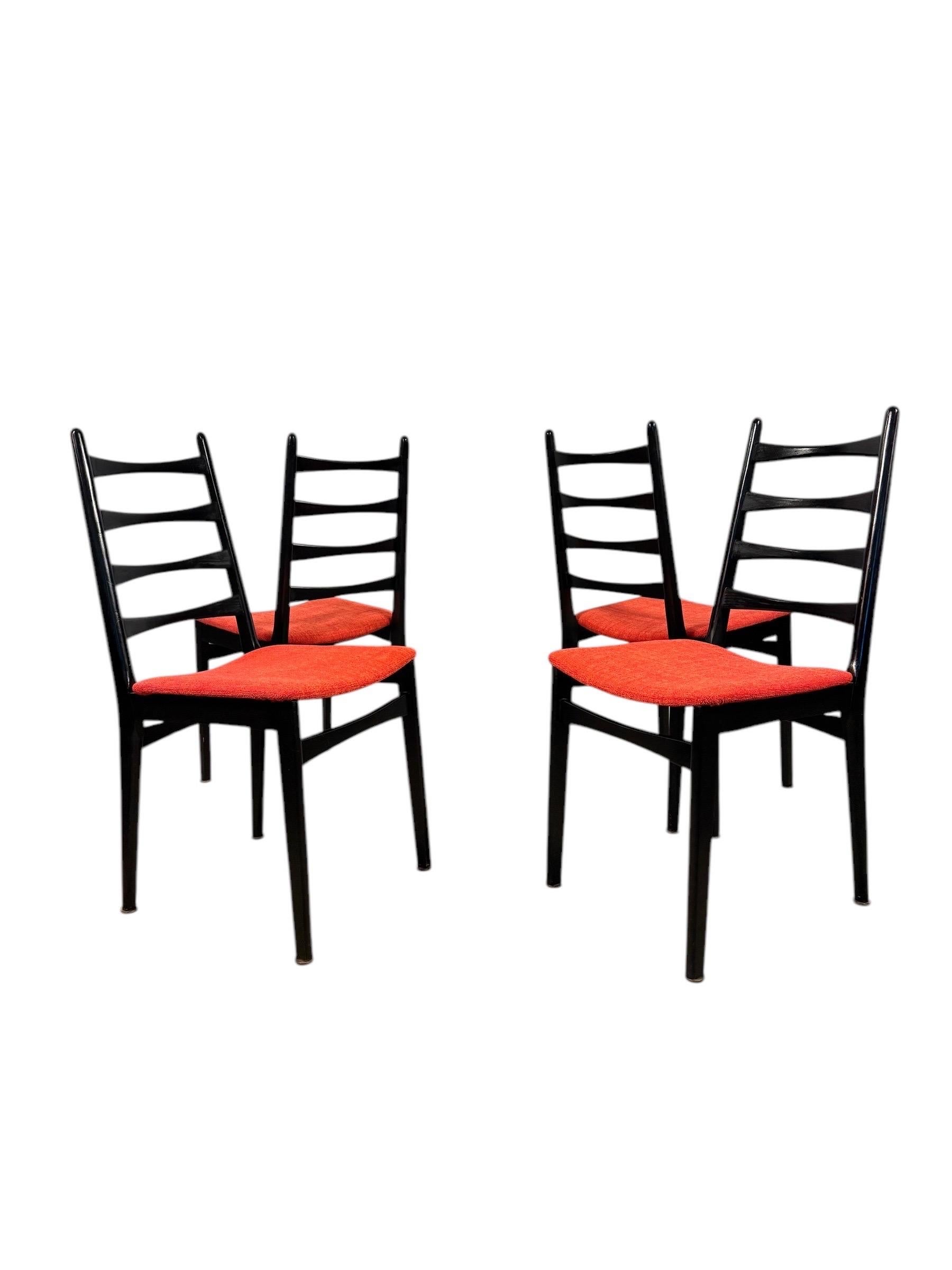 Un sorprendente set di quattro sedie da pranzo italiane dal fascino classico della metà del secolo scorso. Queste sedie scultoree con schienale a scaletta sono caratterizzate da un'elegante struttura nera e da sedute recentemente ridipinte in un