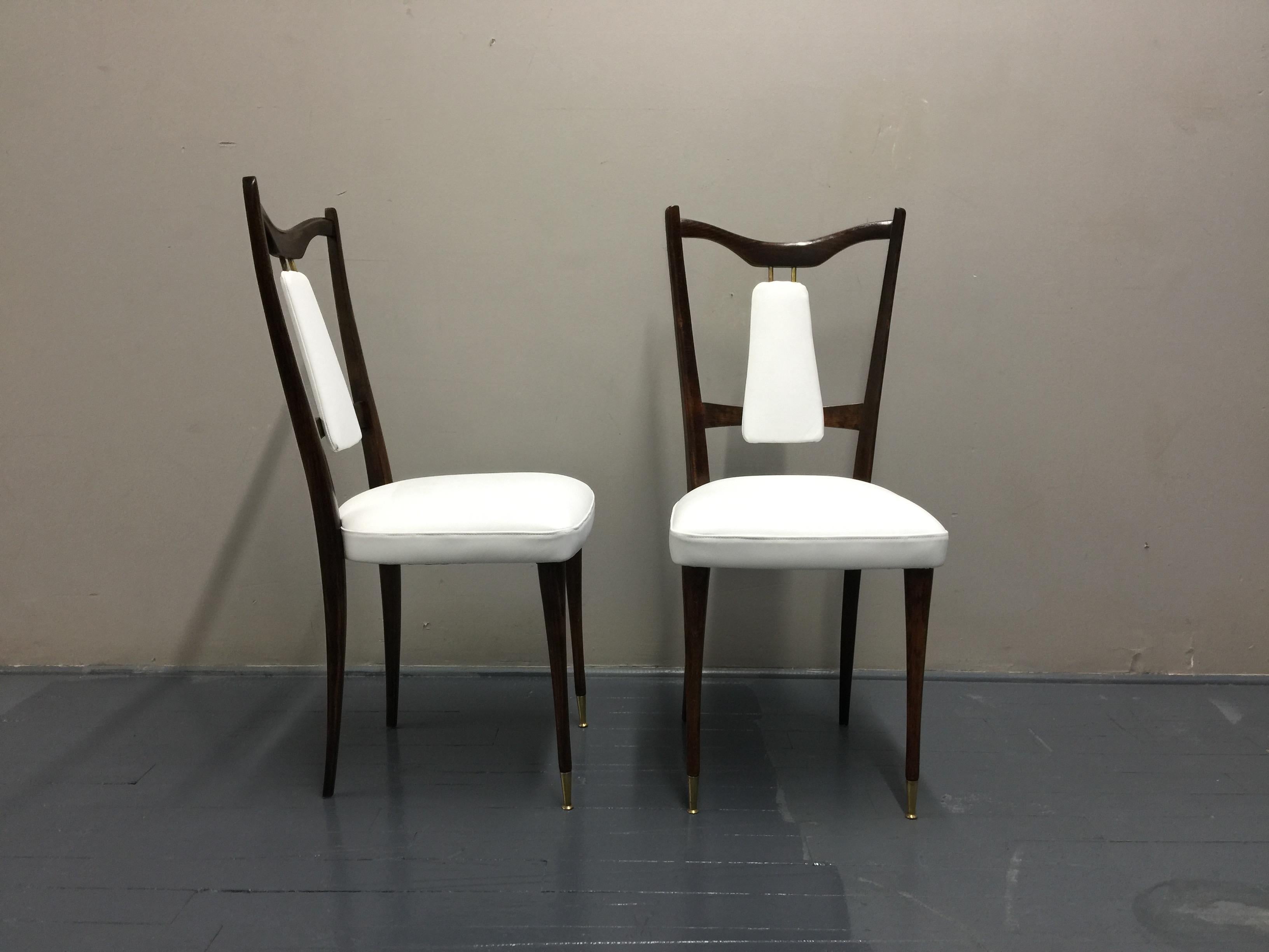 Set of 4 Italian midcentury dining room chairs, re-covered with new white leather, wood structure and wooden legs with brass feet, circa 1950s. Good vintage condition for the structure, brand new white leather cover and padding. This set is made of