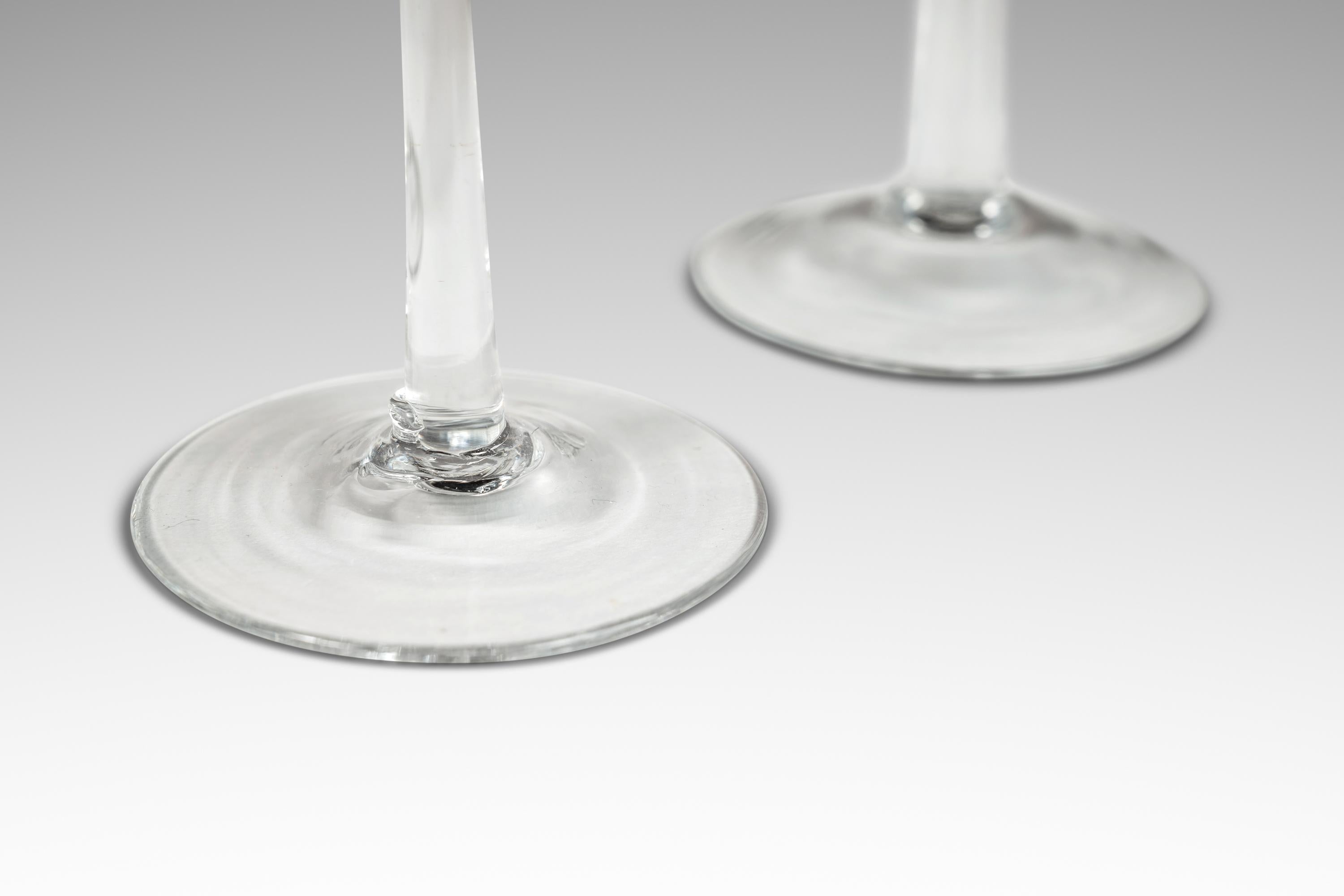 Introducing an artfully crafted set of four Italian Modern blown glass candlestick holders. Like snowflakes no two are alike and each is ever so slightly different in size and shape. With elegant elongated shapes these exquisite art pieces feature a