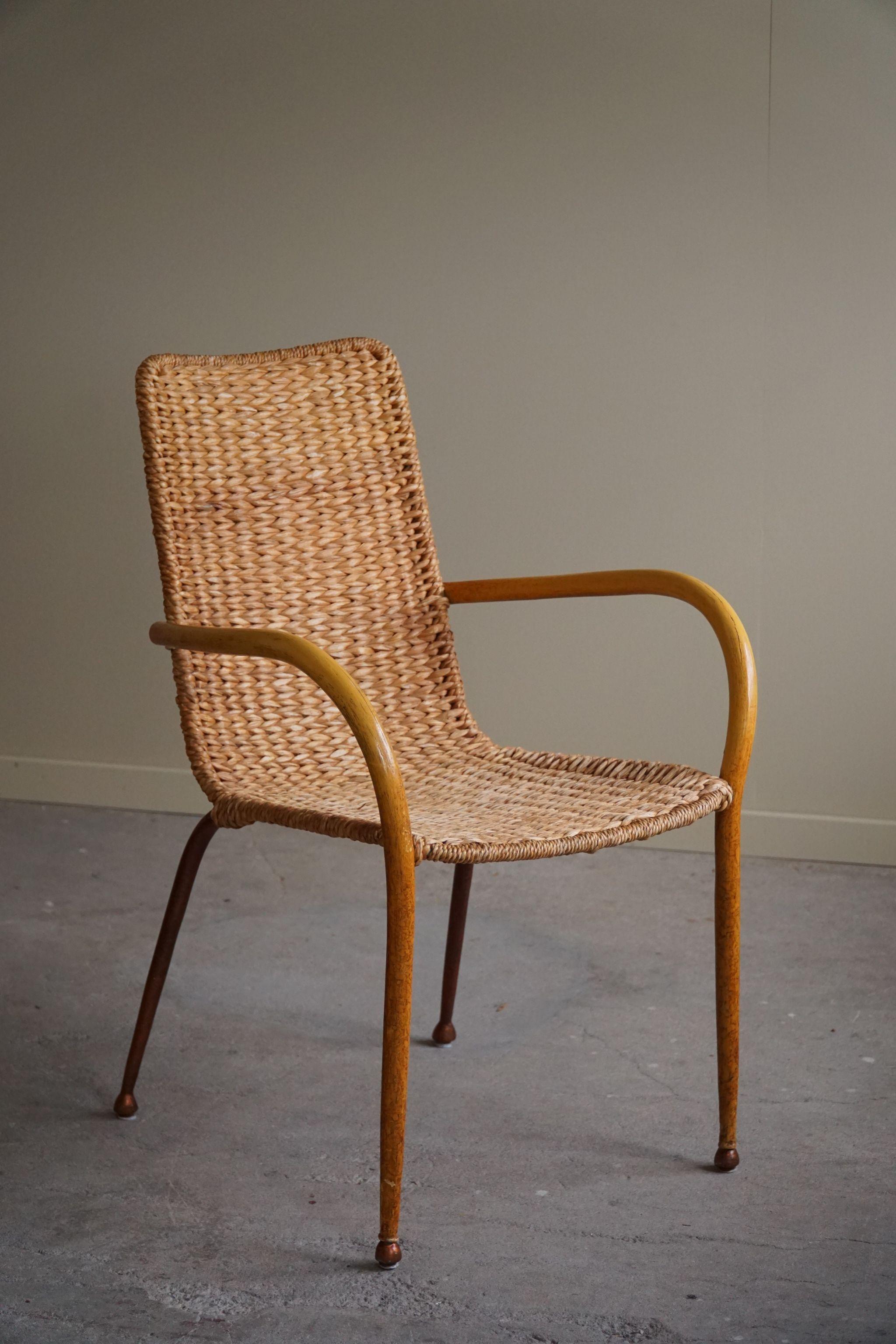 A truly beautiful set of 4 armchairs with hand woven wicker seats and back. Arms in a veneered birch attached to a metal frame, an unusual detail that we have never seen before. Made in Italy by an unknown designer and maker, which makes this set