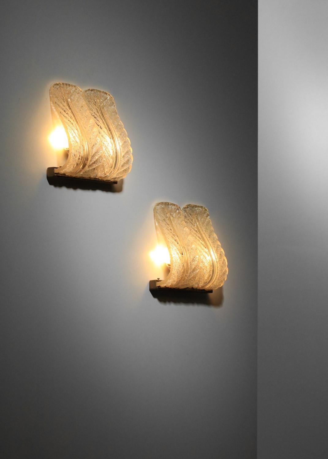 Suite of four 1930s sconces attributed to the Italian firm Barovier & Toso. Solid brass base and sockets, gilded Murano glass shades depicting leaves. Very fine vintage condition with a beautiful patina on the brass, with traces of use and age (see