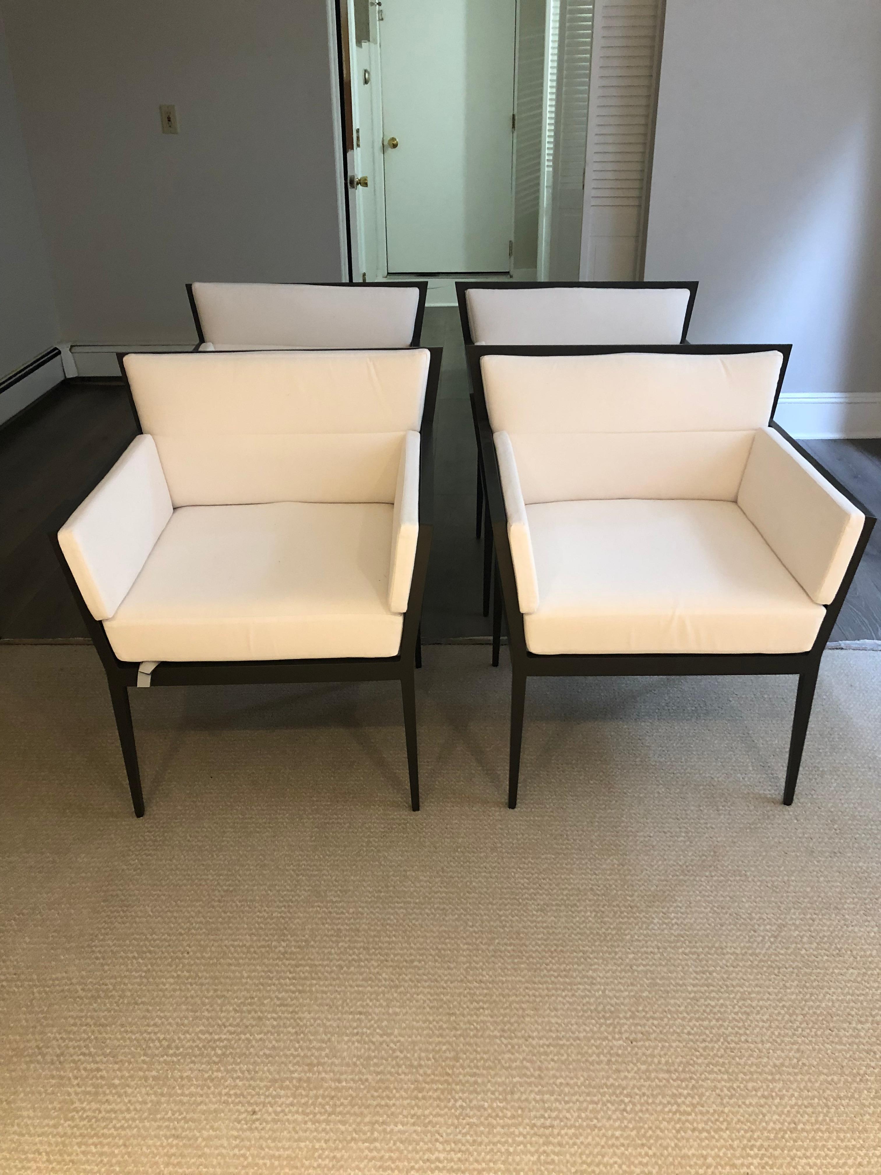 Incredibly chic set of 4 dark grey aluminum outdoor club or dining chairs with a movie star vibe having crisp Sunbrella white interior cushions. Designed by Janus et Cie, these are meant more for the patio because of their light weight and durable
