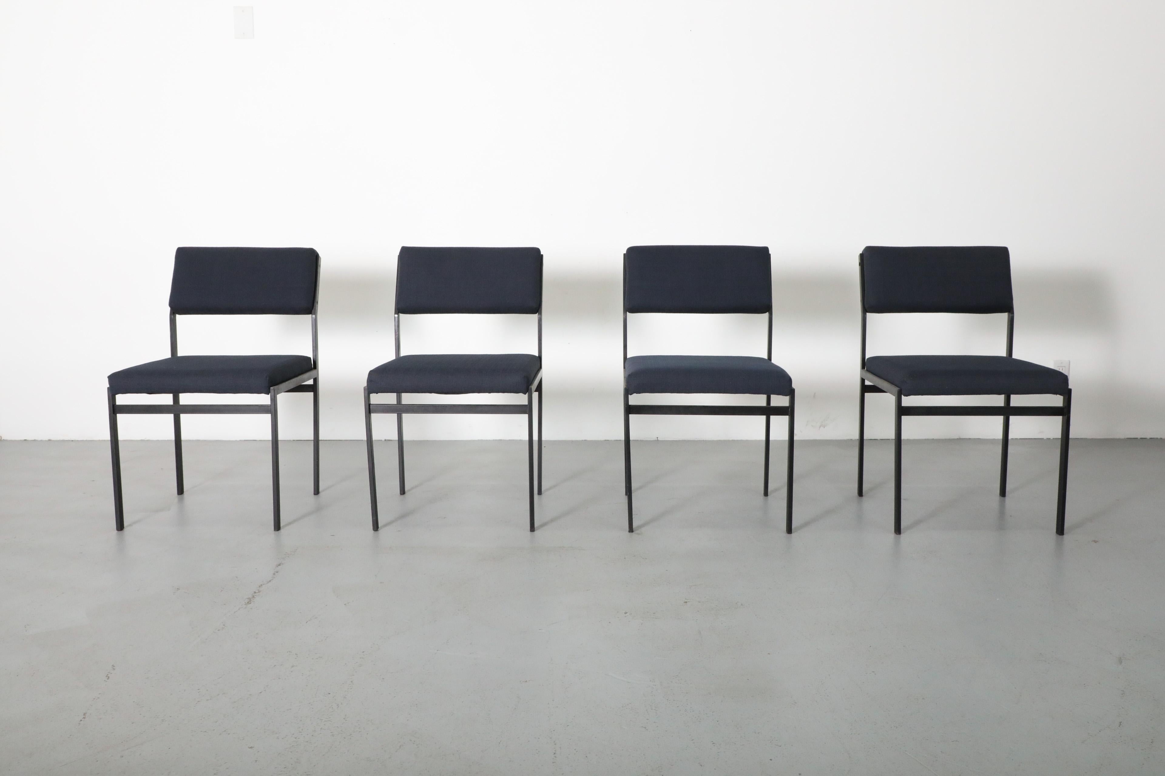 This set of four stylish chairs was designed by Dutch designer Cees Braakman for Dutch Post-war powerhouse furniture manufacturer Pastoe. They have black enameled metal frames and are handsomely outfitted with new navy blue upholstery. The chairs
