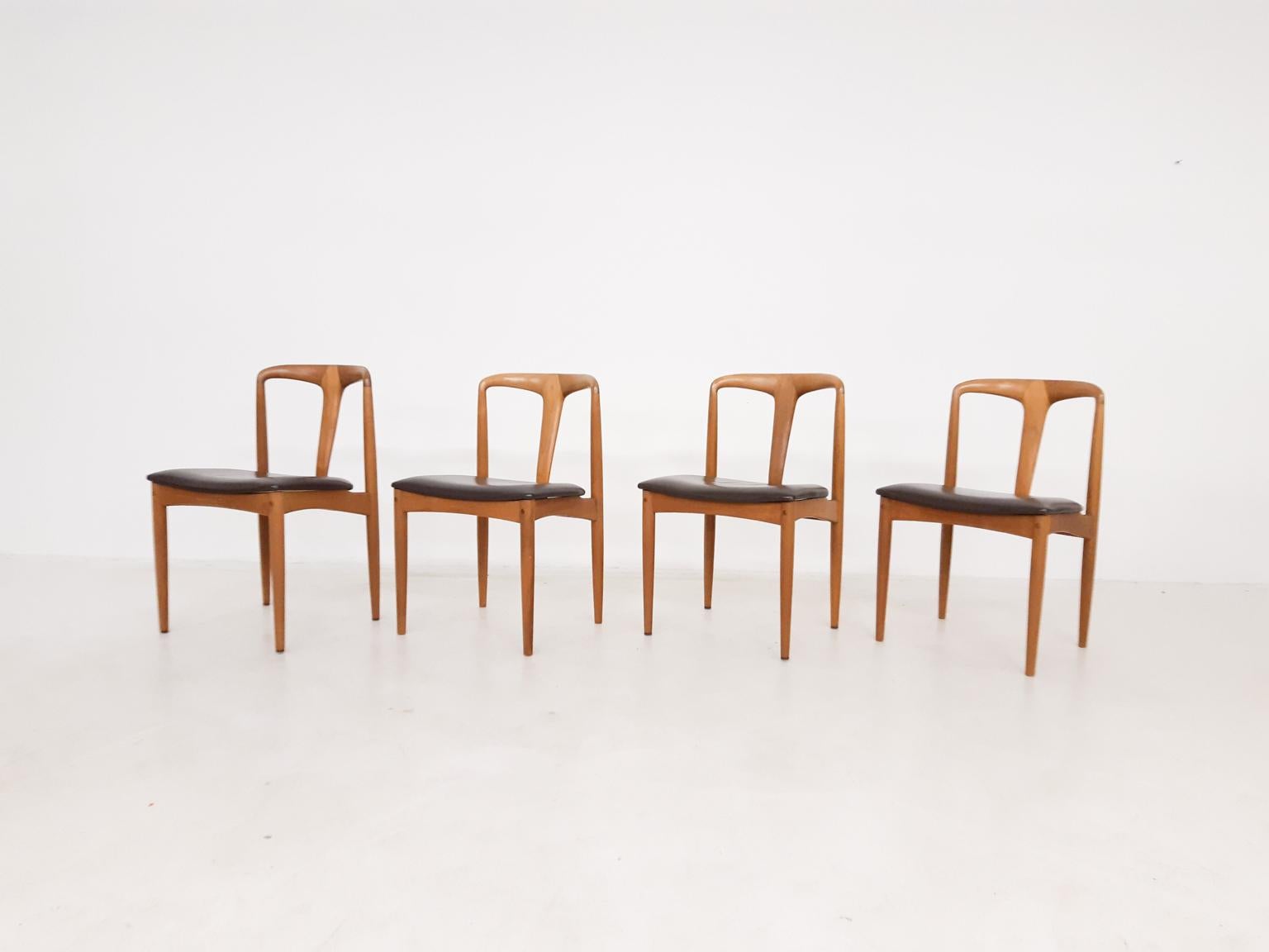 Set of four Danish design dining chairs made of oak and designed by Johannes Andersen. The chairs are produced by Uldum Möbelfabrik in Denmark in the 1950s. The chairs have original dark brown leather upholstery, which is in good condition.

Pure