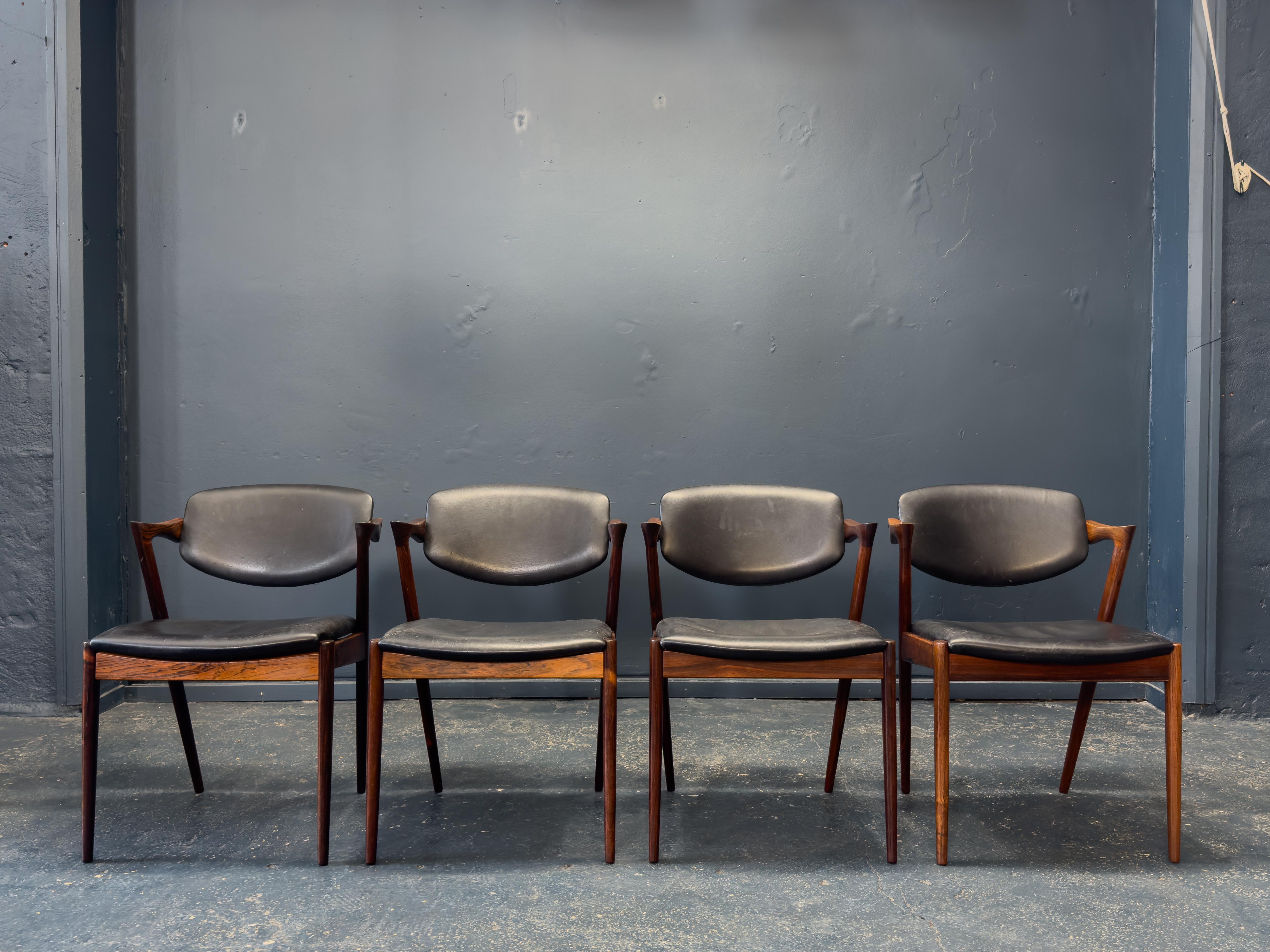 Este excepcional juego de cuatro sillas de comedor Modelo 42, de Kai Kristiansen, es un excelente ejemplo del diseño moderno danés de mediados de siglo en su máxima expresión. Estas sillas, fabricadas con maderas suntuosamente ricas, son famosas por
