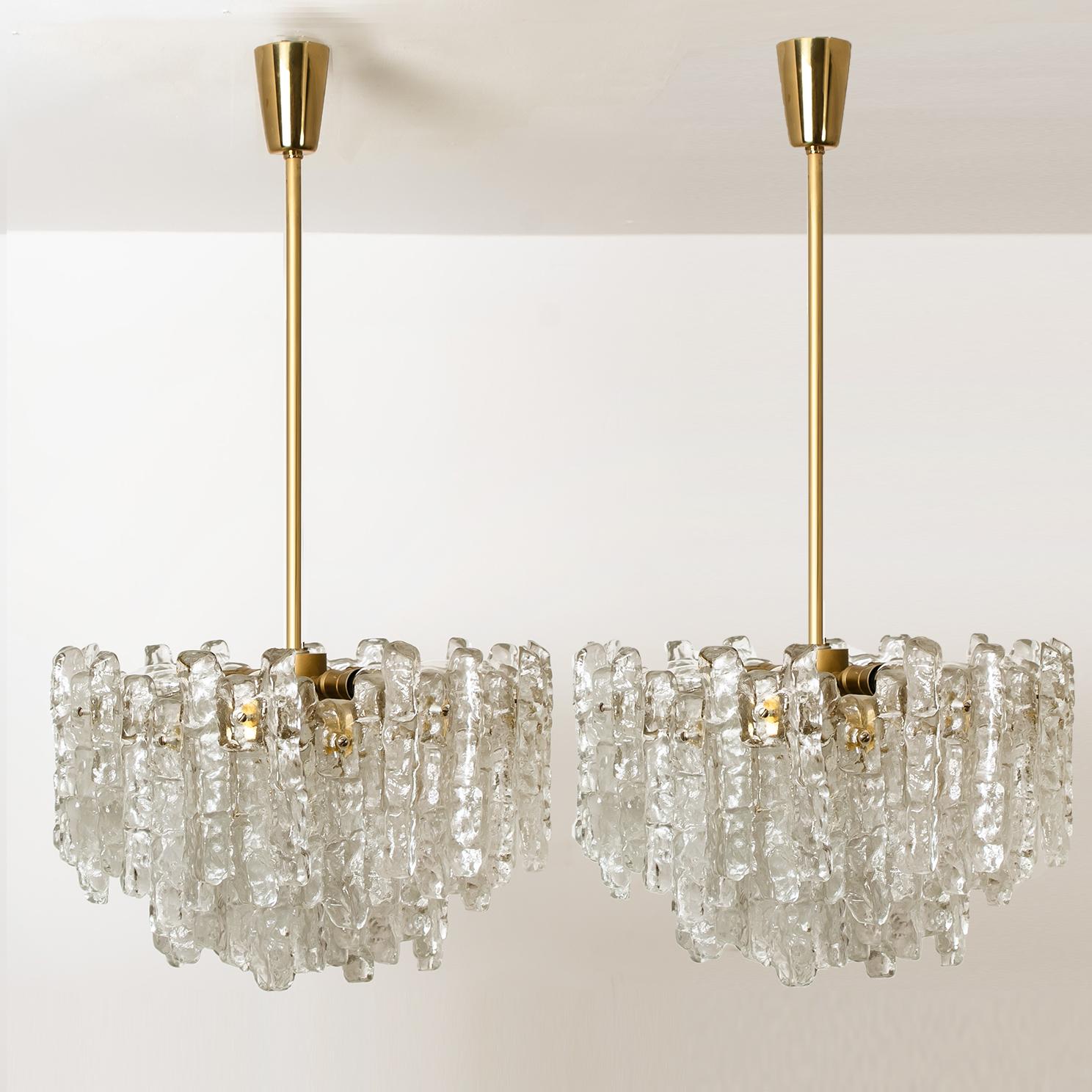 Unique and elegant modern high-end brass colored set of light fixtures, manufactured by Kalmar, Austria in the 1970s. Lovely design, executed to a very high standard. Each chandelier has trier layers of extremely stylish textured solid ice glass