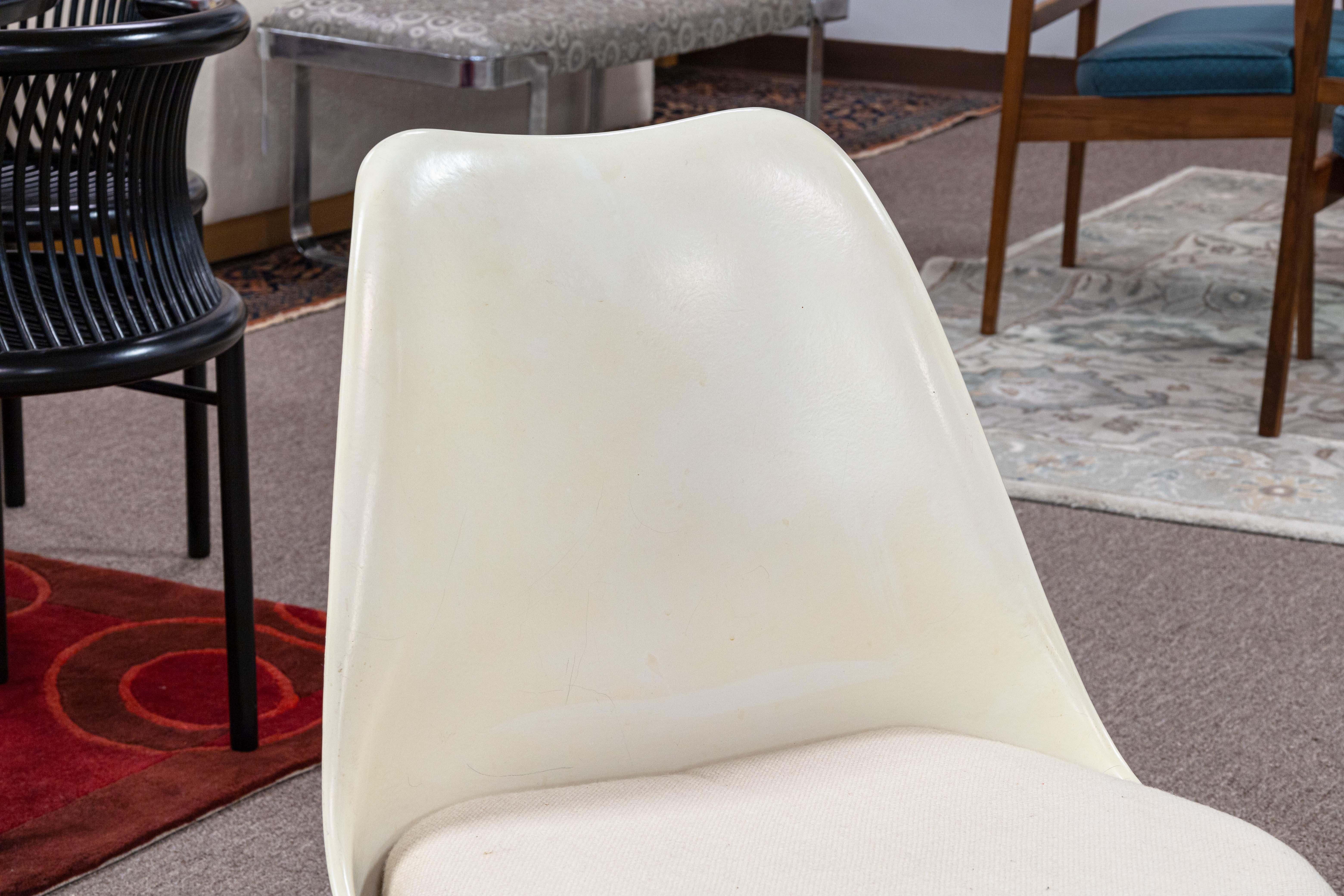 A set of 4 Knoll tulip chairs. An iconic set of vintage tulip chairs designed by Eero Saarinen for Knoll. These particular chairs are from the 1970s. They feature the classic white frame, and have beige removable cushions. These chairs a made of