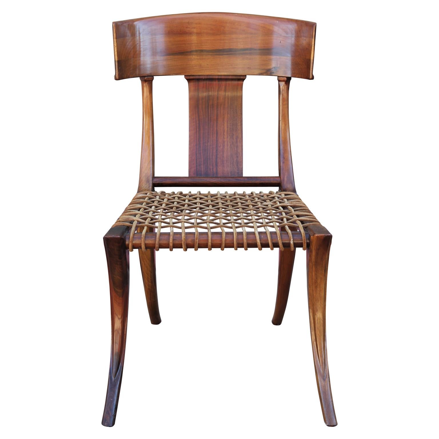 Striking Klismos style dining chairs by Kreiss. Wood construction with woven leather seats. 2 have been sun bleached and can be restored for an additional cost.