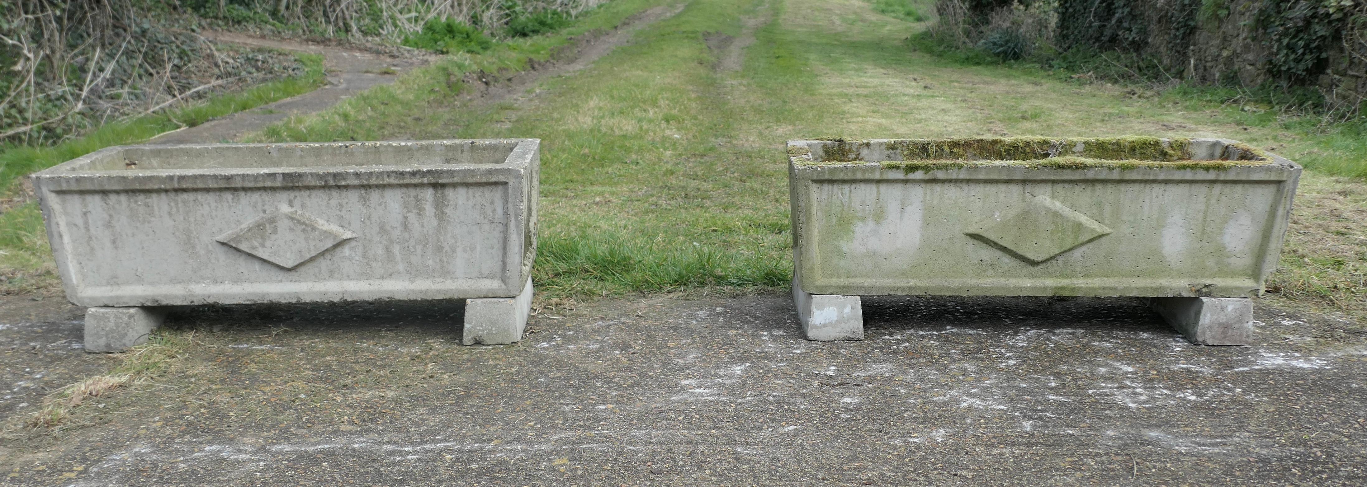 Set of 4 Large Weathered Garden Planters

These giant pieces are rectangular, they all are set on small feet so they drain well.
They all have little decorative motif on the long sides, the planters are well weathered and have large drainage holes