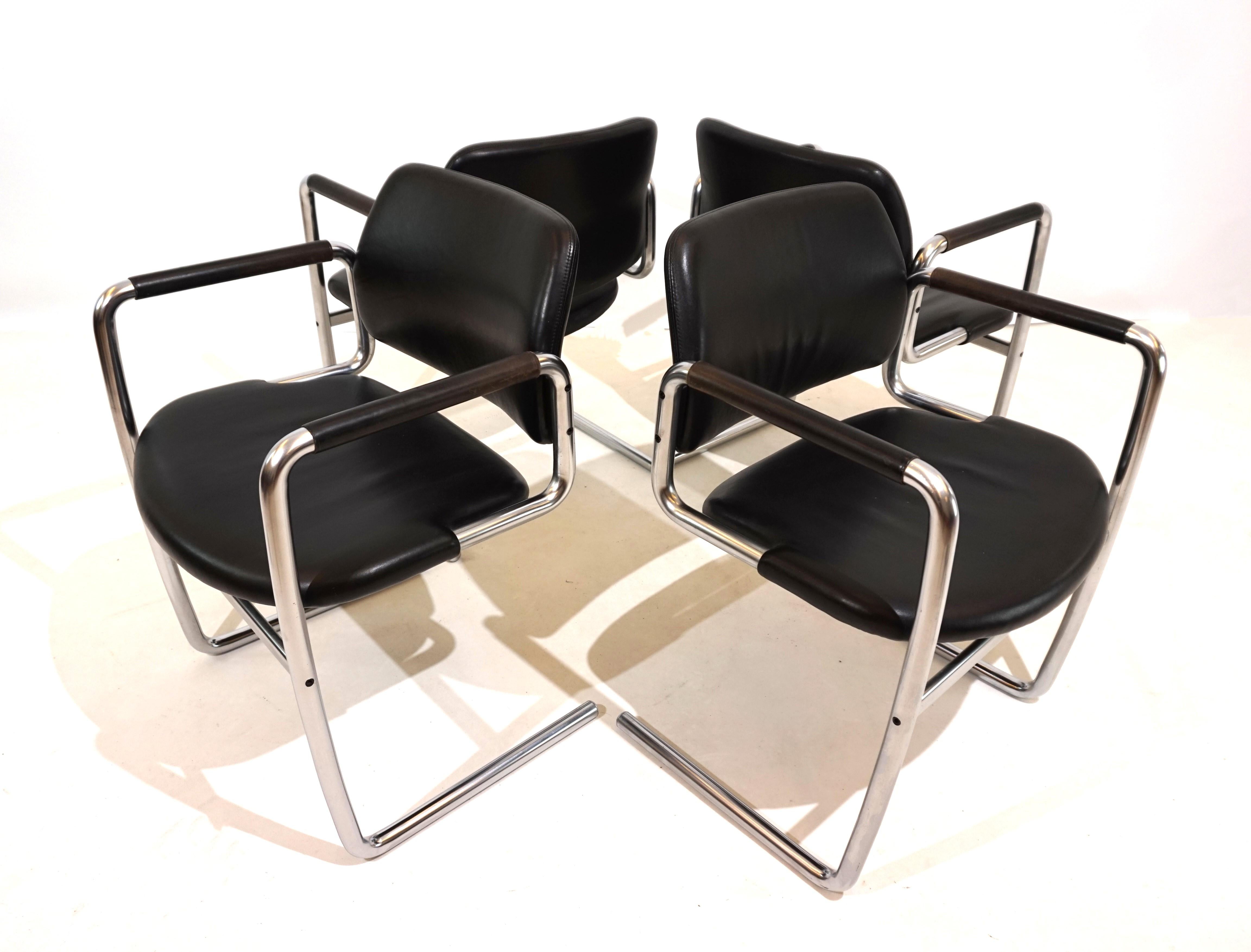 L'ensemble de 4 chaises luge en cuir noir est conçu dans le style typique de Kastholm. Le cadre métallique incurvé d'apparence solide ne soutient l'assise en cuir qu'aux extrémités avant, ce qui confère à la chaise une certaine légèreté. Les sièges