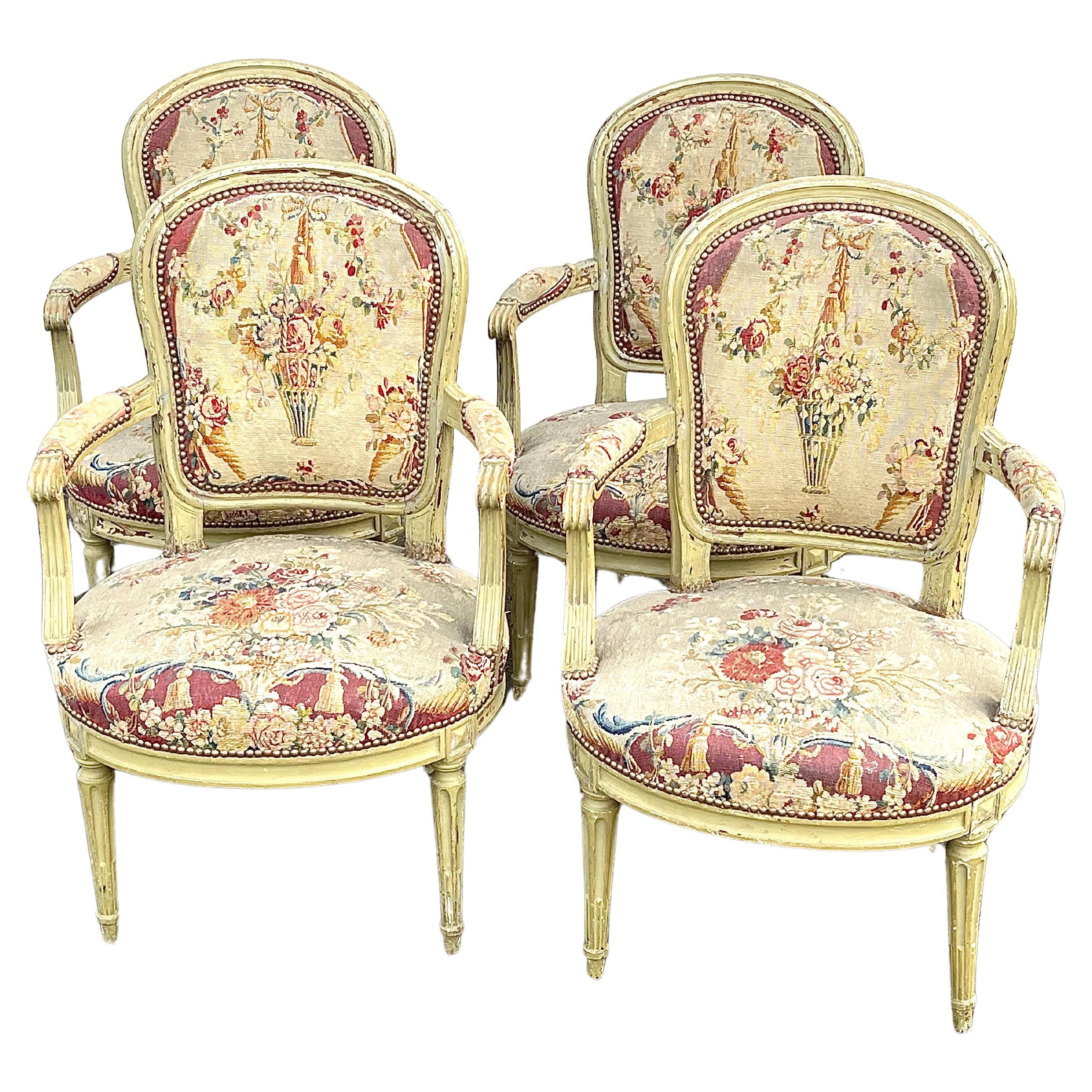 Un ensemble de 4 fauteuils d'époque Louis XVI en finition peinte verte d'origine, avec sièges et dossiers en tapisserie à l'aiguille du 18ème siècle, chaque chaise signée par le fabricant sur le châssis du siège 