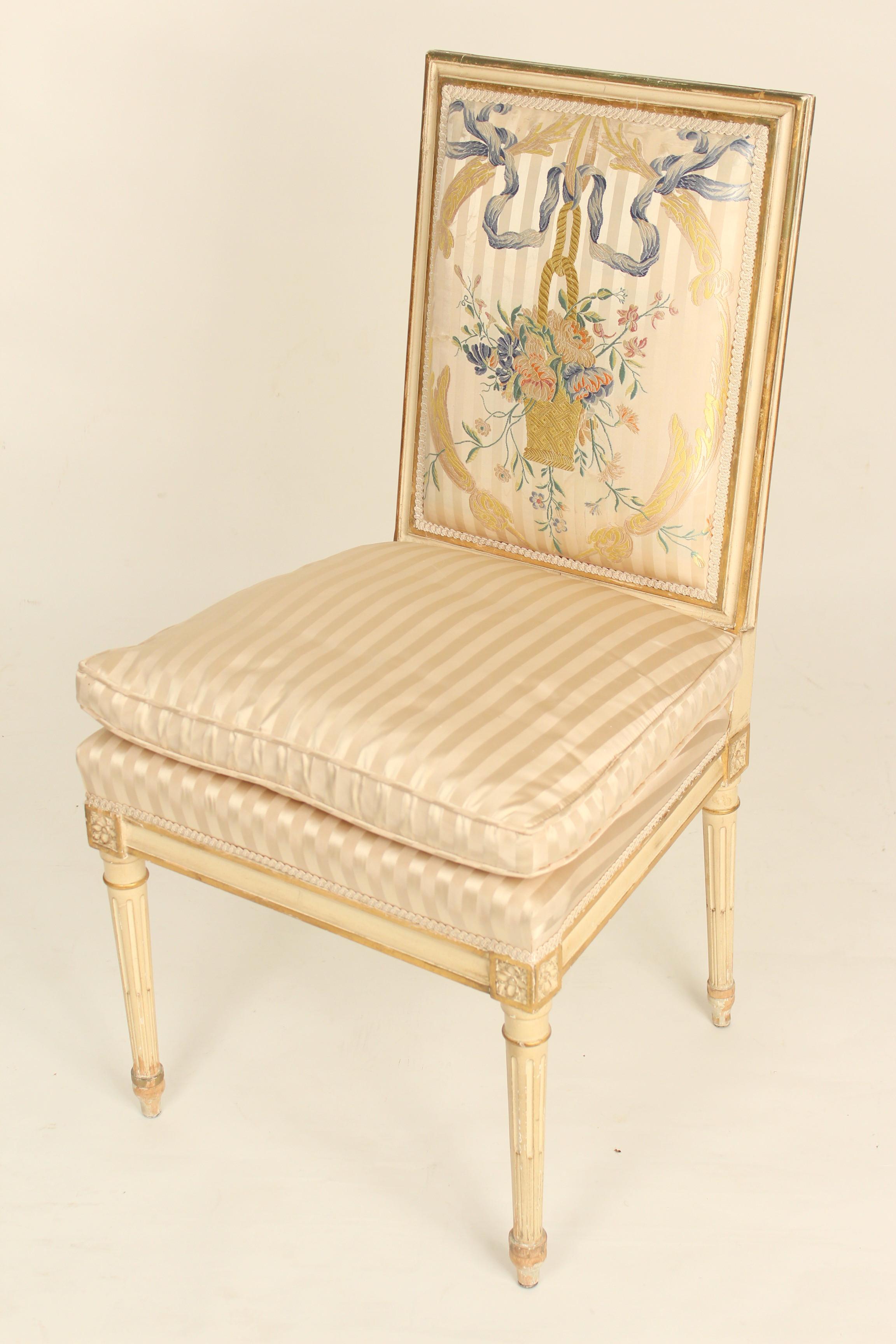 Set of 4 Louis XVI style painted and partial gilt side chairs with silk upholstered seats and silk embroidered backs, circa 1960s.