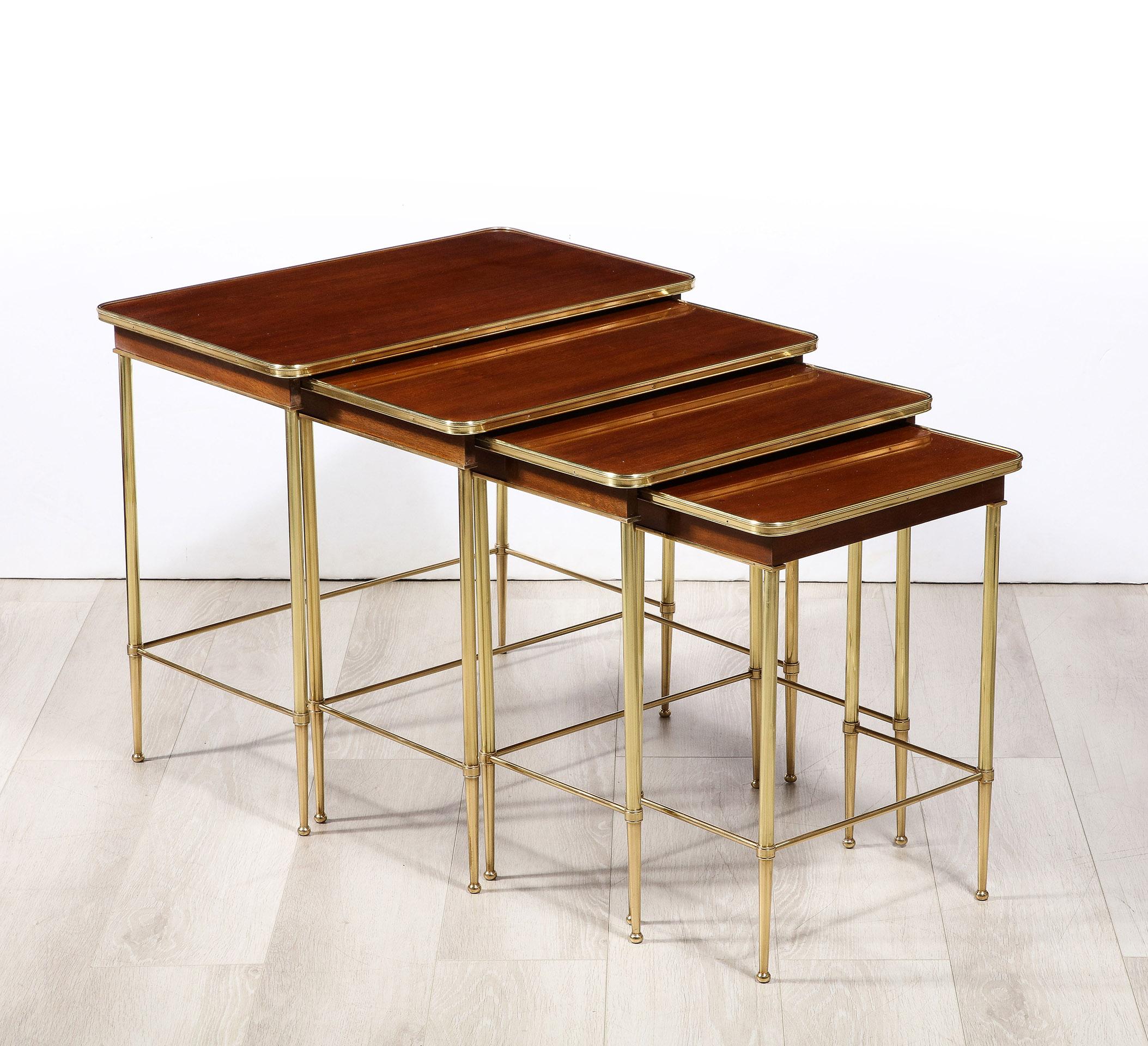 The set of 4 tables having a brass framed mahogany top and mahogany sides on brass legs and each stamped Jansen.