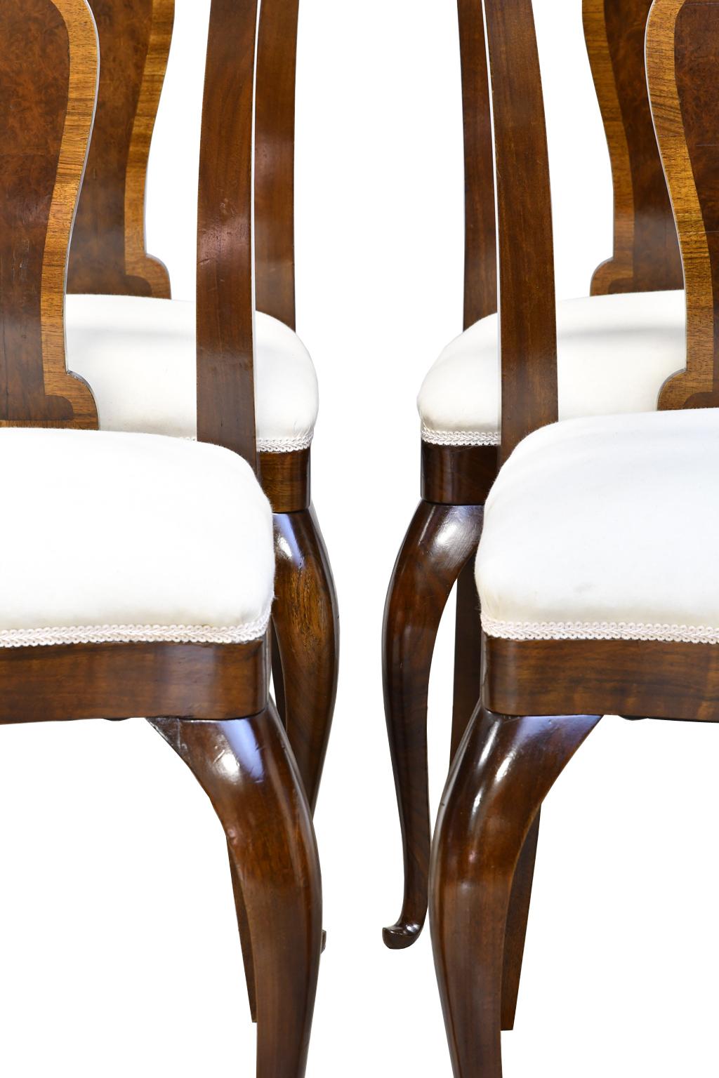 Set of four French Art Deco mahogany dining chairs with upholstered seats, circa 1910-1920.
Frame of chair is mahogany, while the back splat is crossbanded in a flat cut walnut and veneered with burled walnut in the center.
Chairs are French