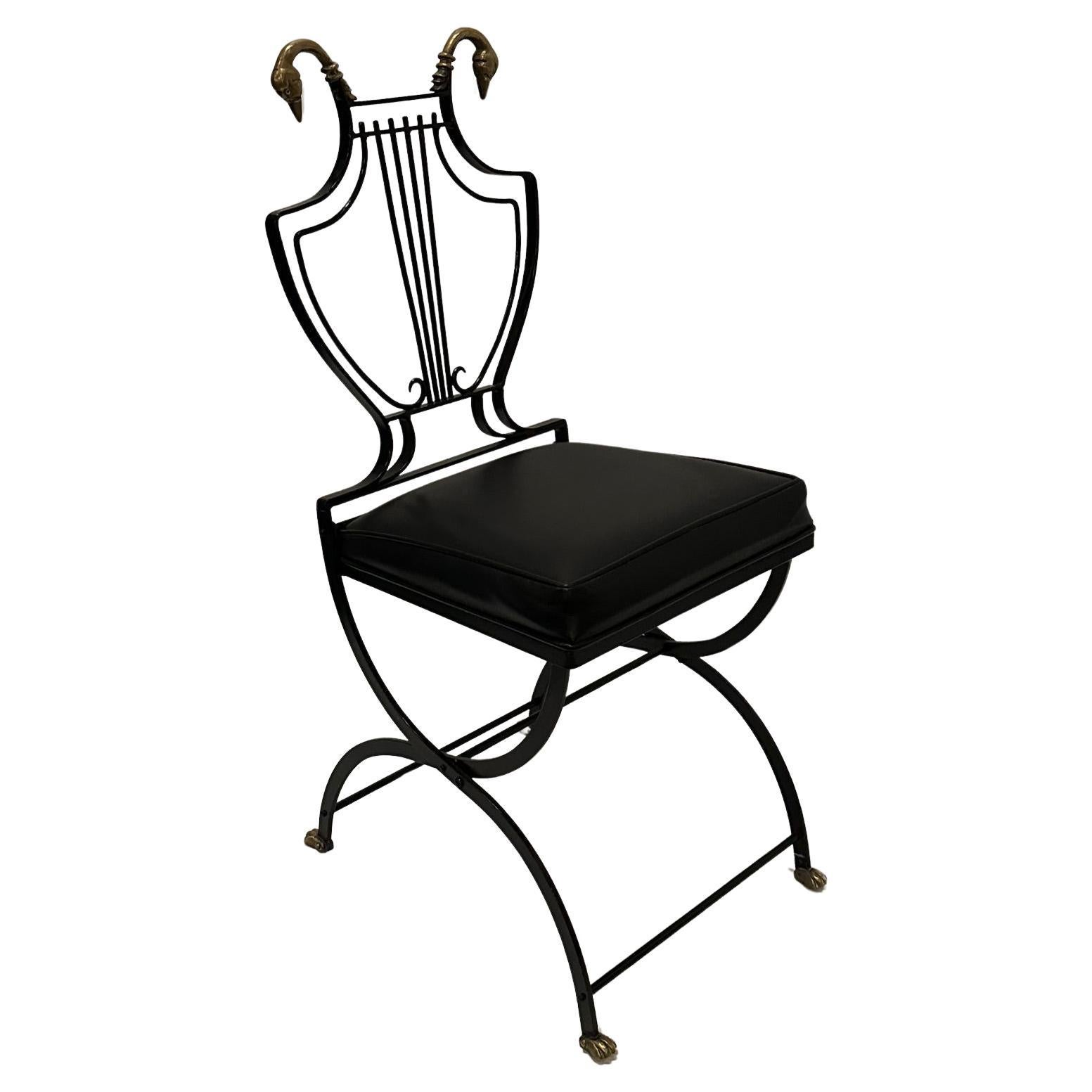 Ensemble de 4 chaises de salle à manger exquises à dossier et cadre lyre en fer noir avec d'étonnantes têtes de cygne en laiton au sommet et des pieds en patte d'oie à la base des élégants pieds minces.  Les sièges sont en vinyle noir.