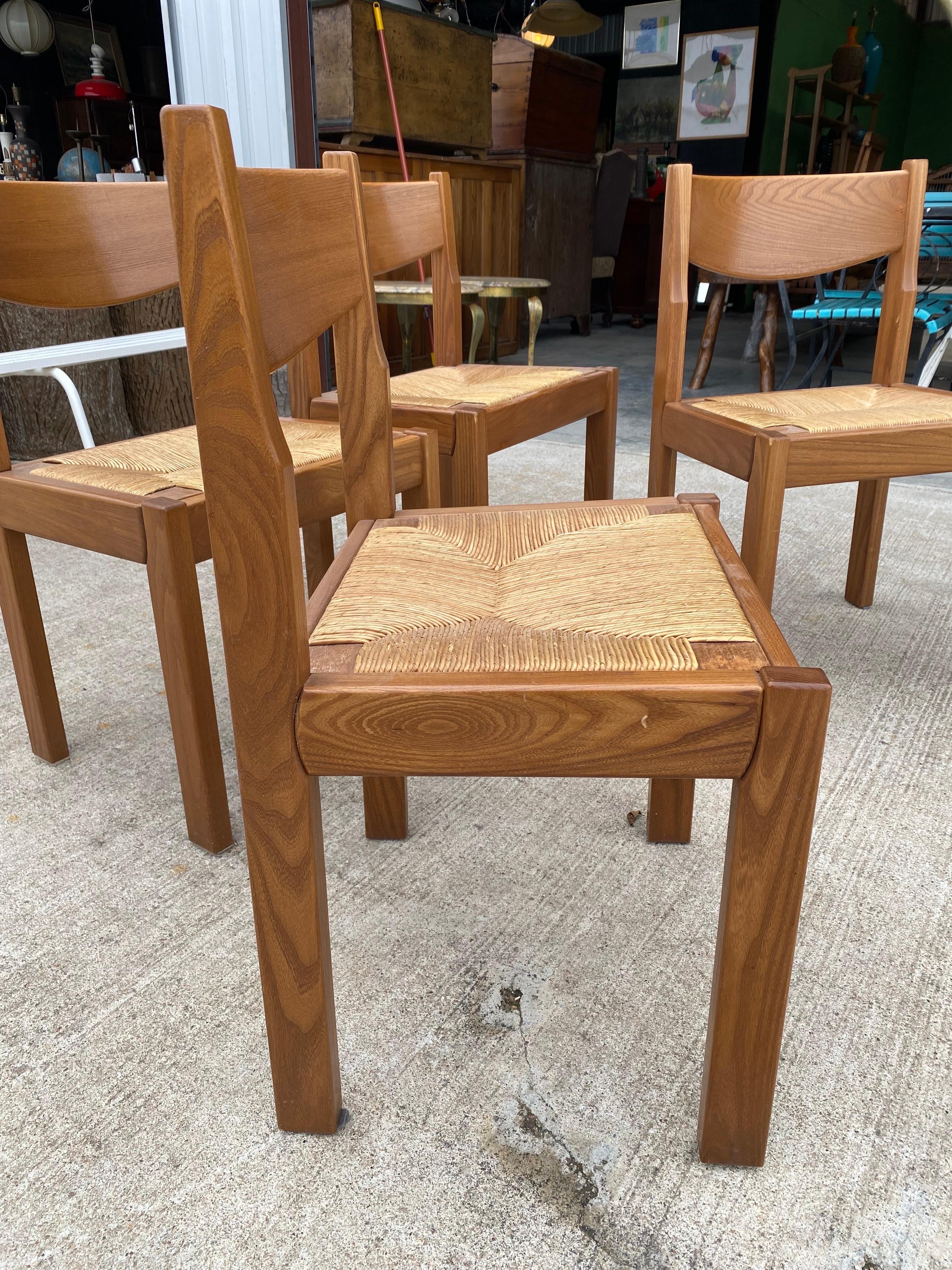 Set of 4 vintage brutalist Maison Regain dining chairs made of solid elm with seagrass seats, circa 1970s, France. Seats come off of the frame for easy shipping. Chairs are sturdy and in good overall condition; rush in great condition. 
Dimensions: