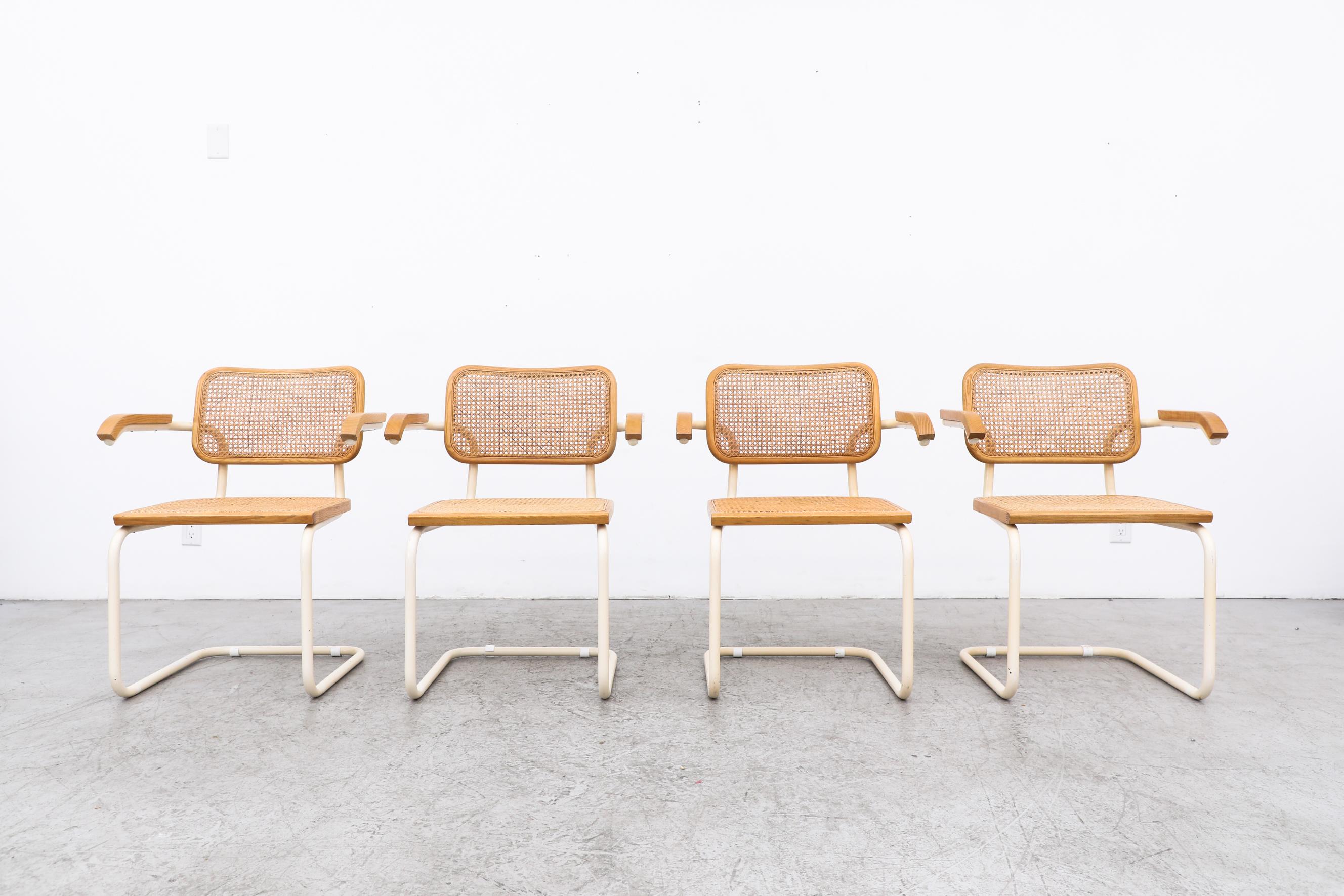 This set of 4 classic B64 Cesca Chairs, designed by famed design icon Marcel Breuer, was manufactured by Gavina in Italy circa 1960. Named 'Cesca' after Breuer's daughter Francesca, these light wood and cane armchairs have a white painted metal
