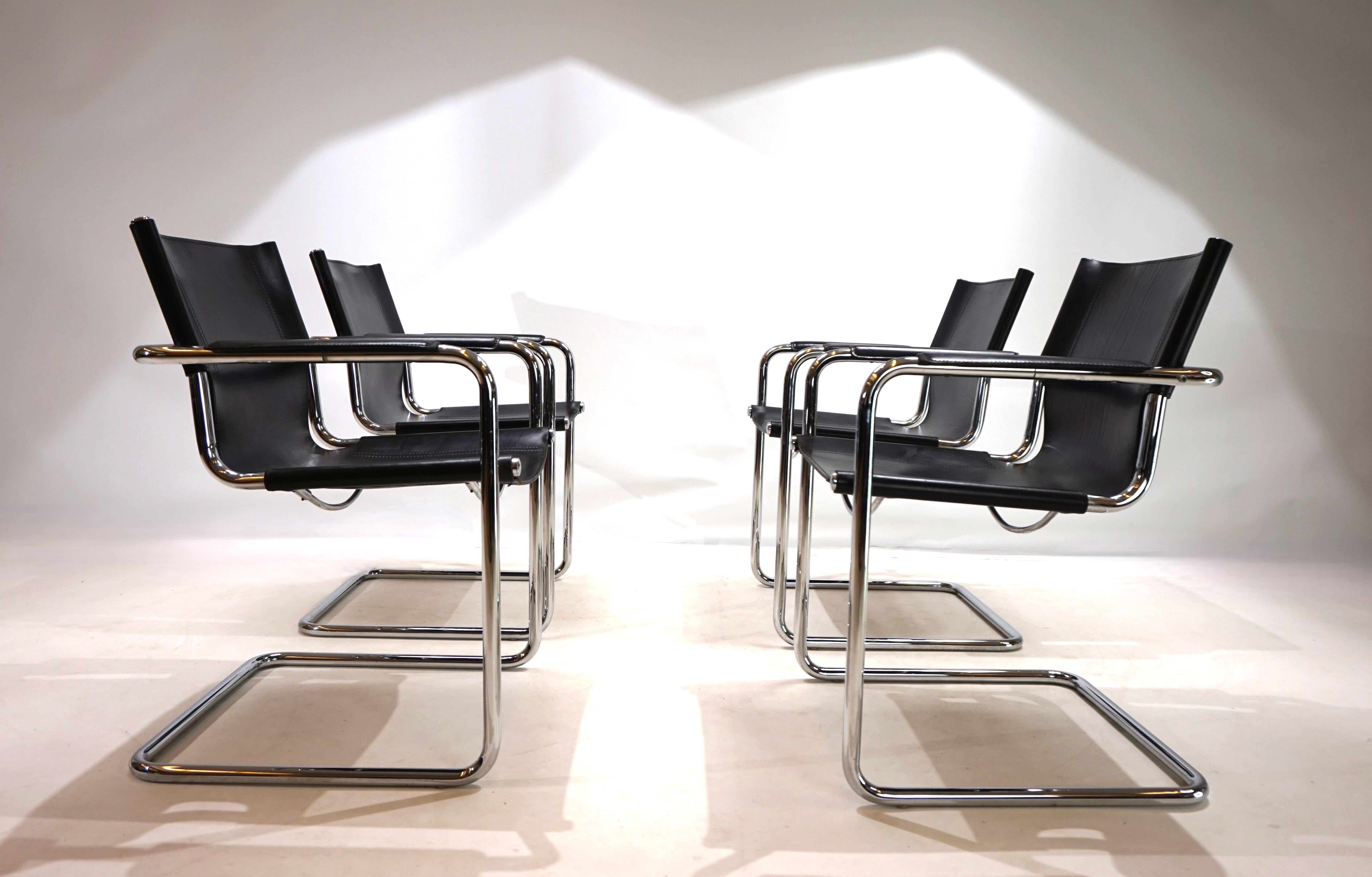 A classic cantilever set of 4 MG6 chairs in black saddle leather which is in very good condition. The thick leather shows minimal signs of wear, the chrome rods are in very good condition. The armrests are undamaged and the seams are solid. One of