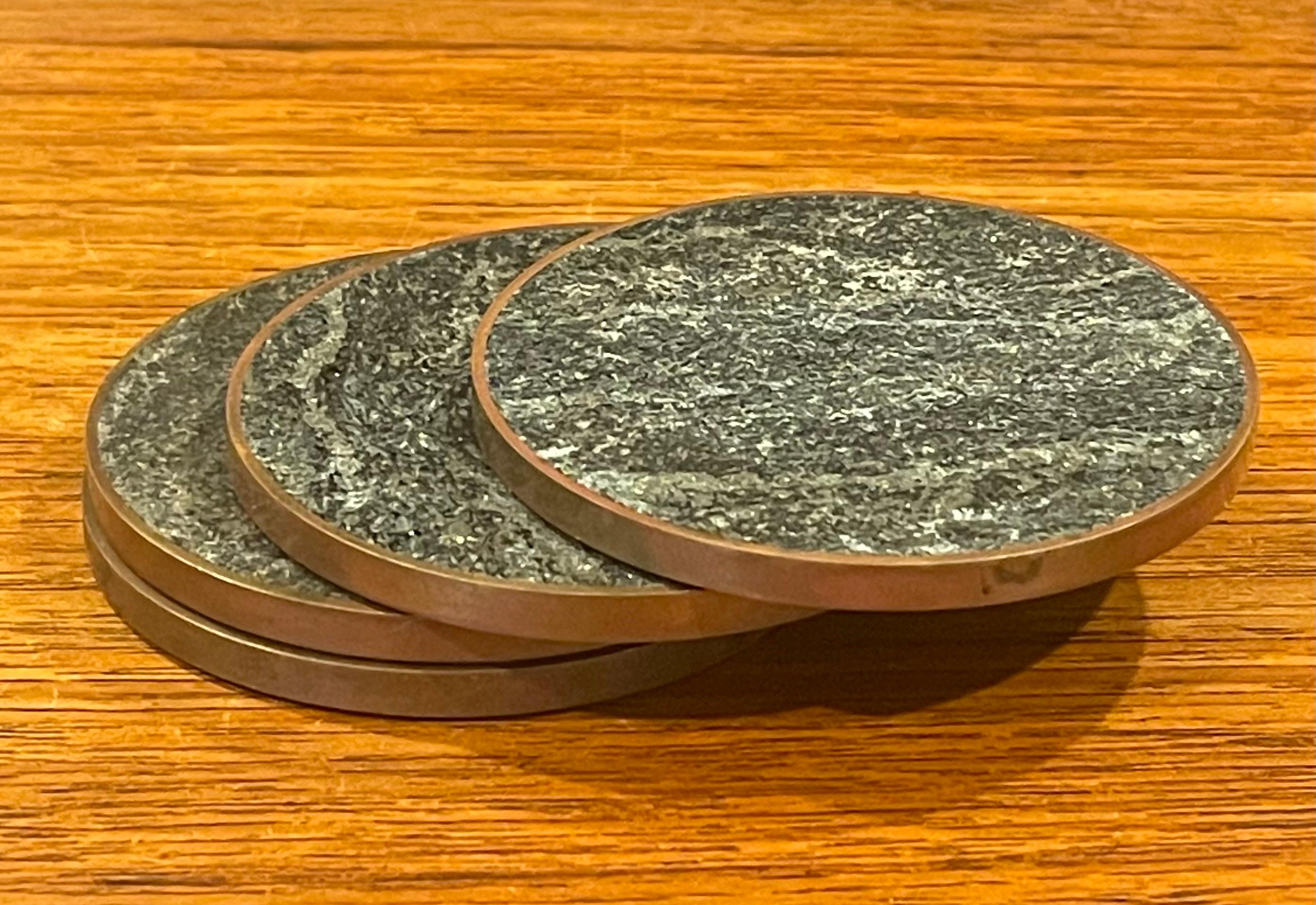 Nice set of four Scandivanian modern polished stone and brass round drink coasters by Saulo, circa 1970s. The coasters are in very good vintage condition and measure 3.25