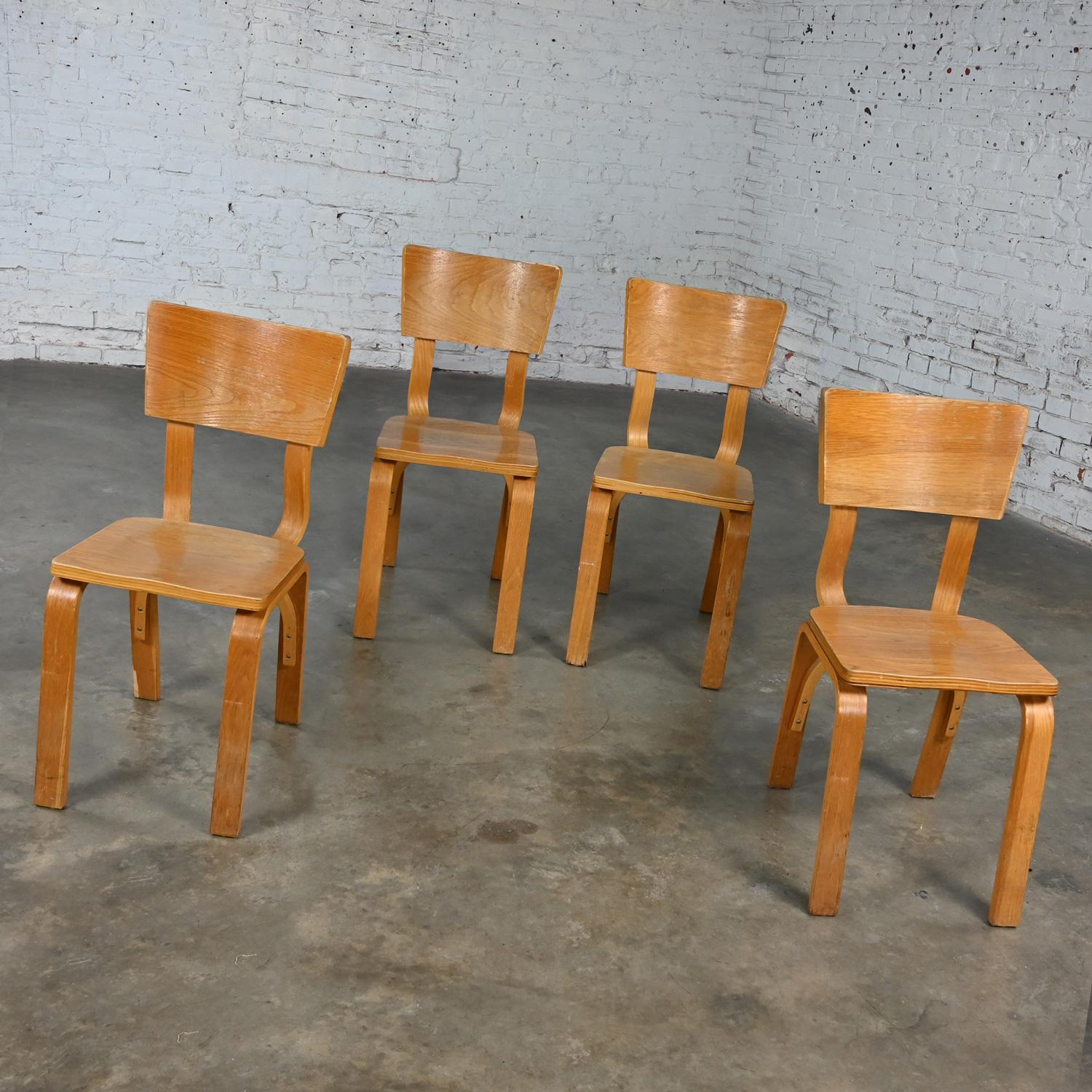 Marvelous vintage Mid-Century Modern Thonet #1216-S17-B1 dining chairs comprised of bent oak plywood with saddle seats and a single bow back stretcher, set of 4, as is condition. See note below regarding refinishing options. Beautiful condition,