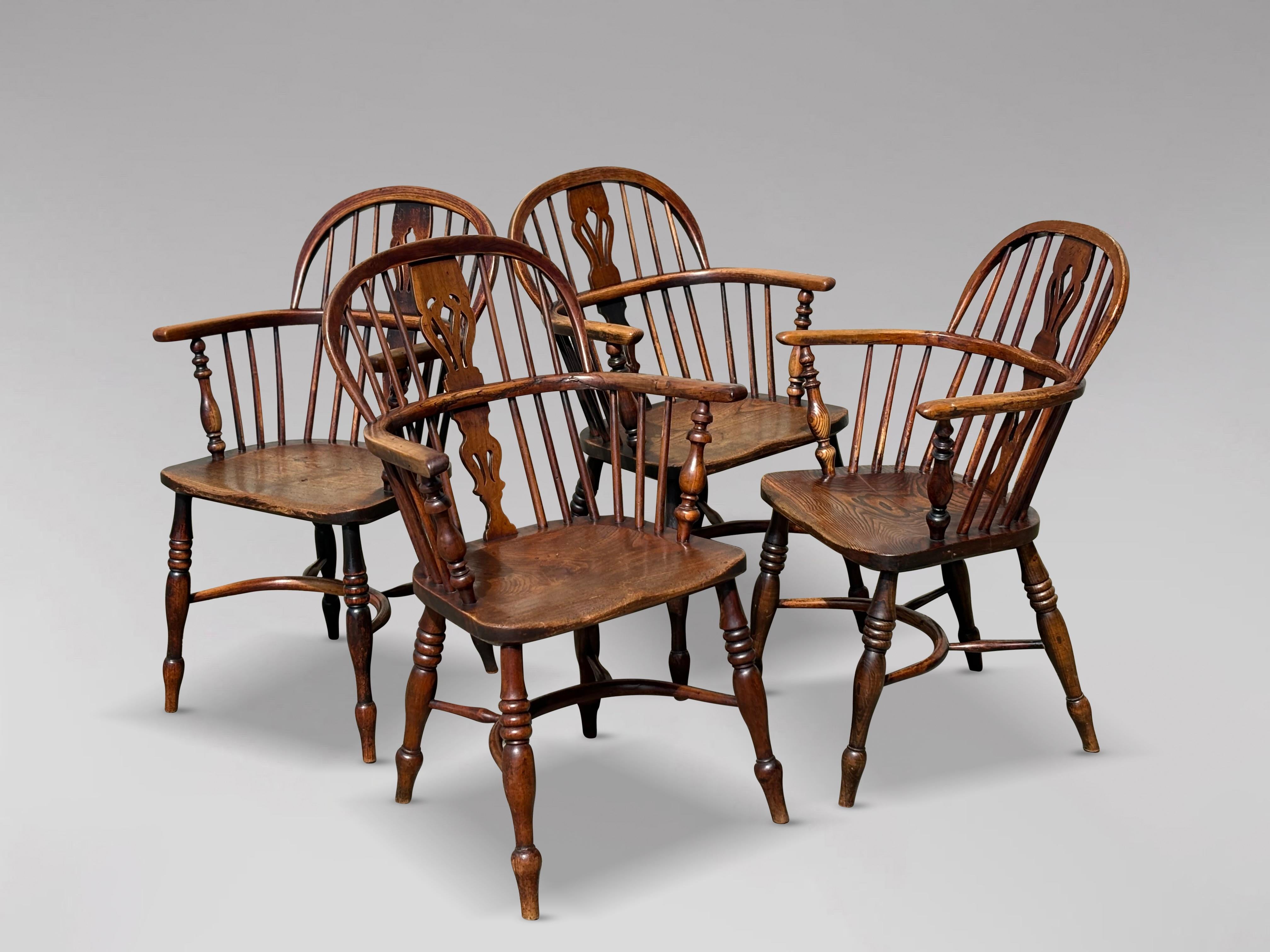 Un raffinato set di 4 poltrone Windsor in quercia e olmo di qualità della metà del XIX secolo. Composto da poltrone Windsor inglesi con schienale basso a bastone e a cerchio in Oak, con stecche forate e fusi a bastone. La spalliera è fissata a una