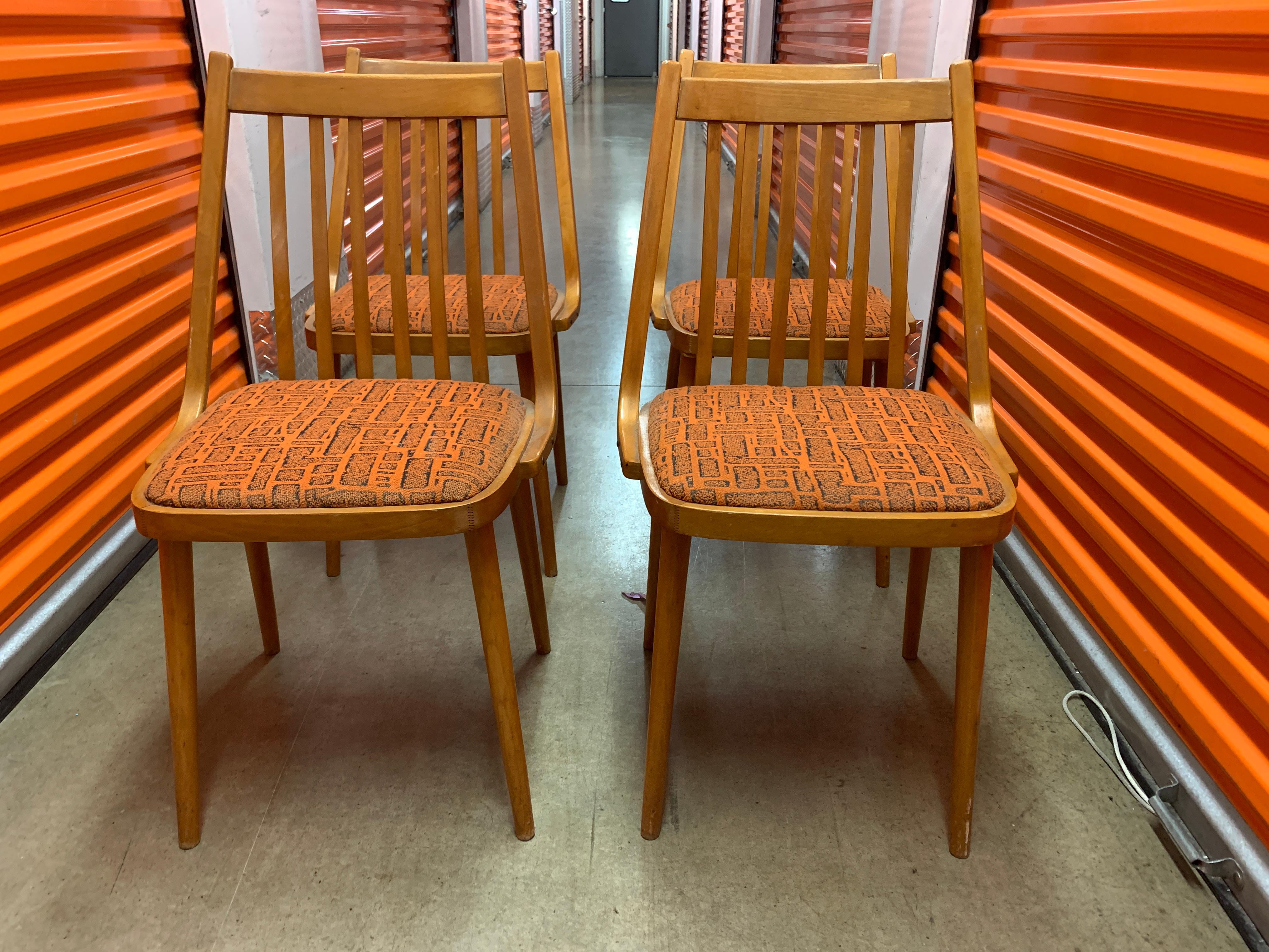 A charming set of teak midcentury Danish dining chairs with an orange and black patterned upholstery would be the perfect addition to a home that embraces the Art Deco aesthetic.