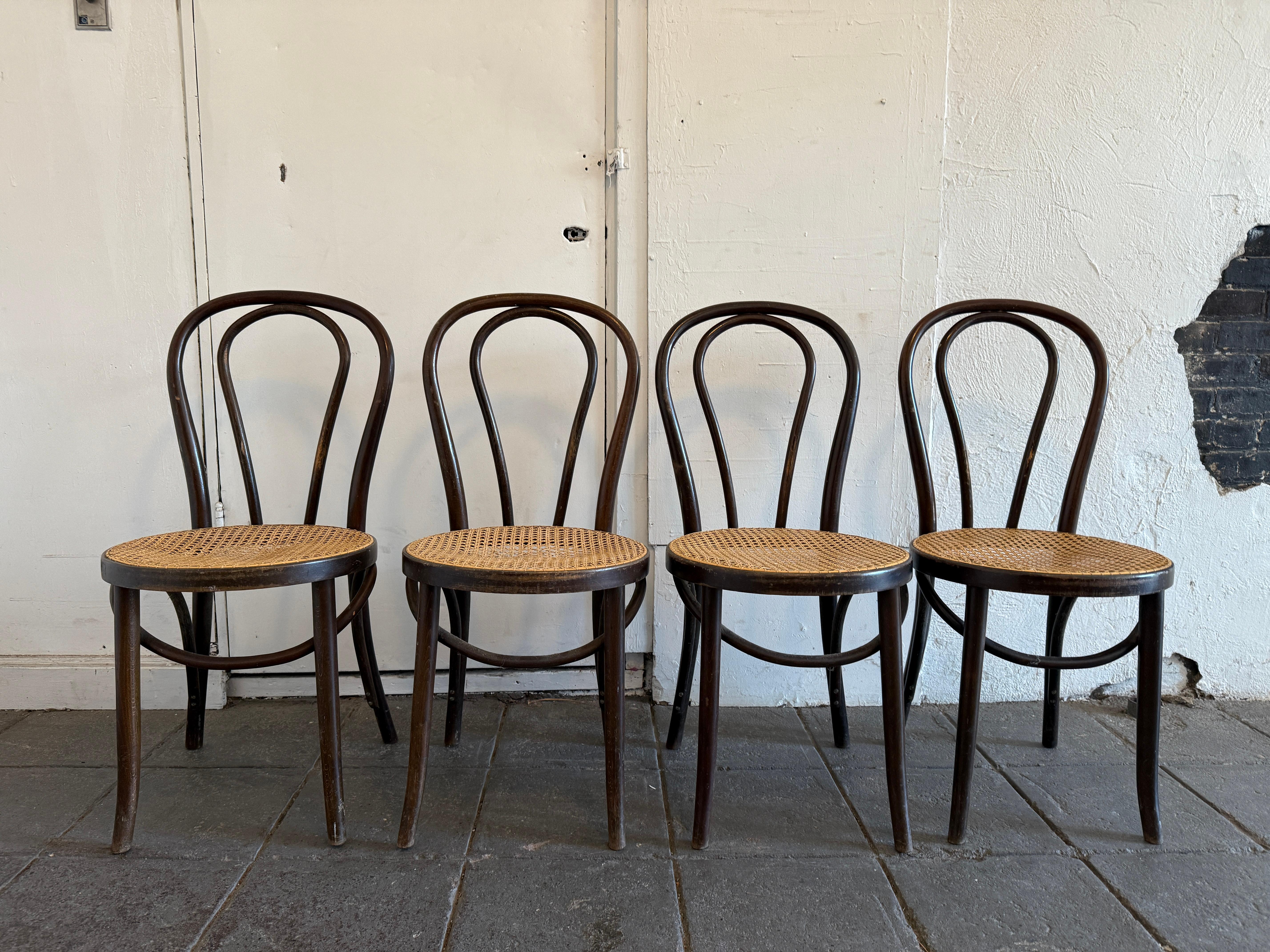 Mid century vintage thonet cafe chairs style number '18' - Set of matching 4 in original condition with patina. The wood has been oiled showing honest wear and ready for use. All chairs are sturdy and Beautiful Patina bentwood all cane seats are