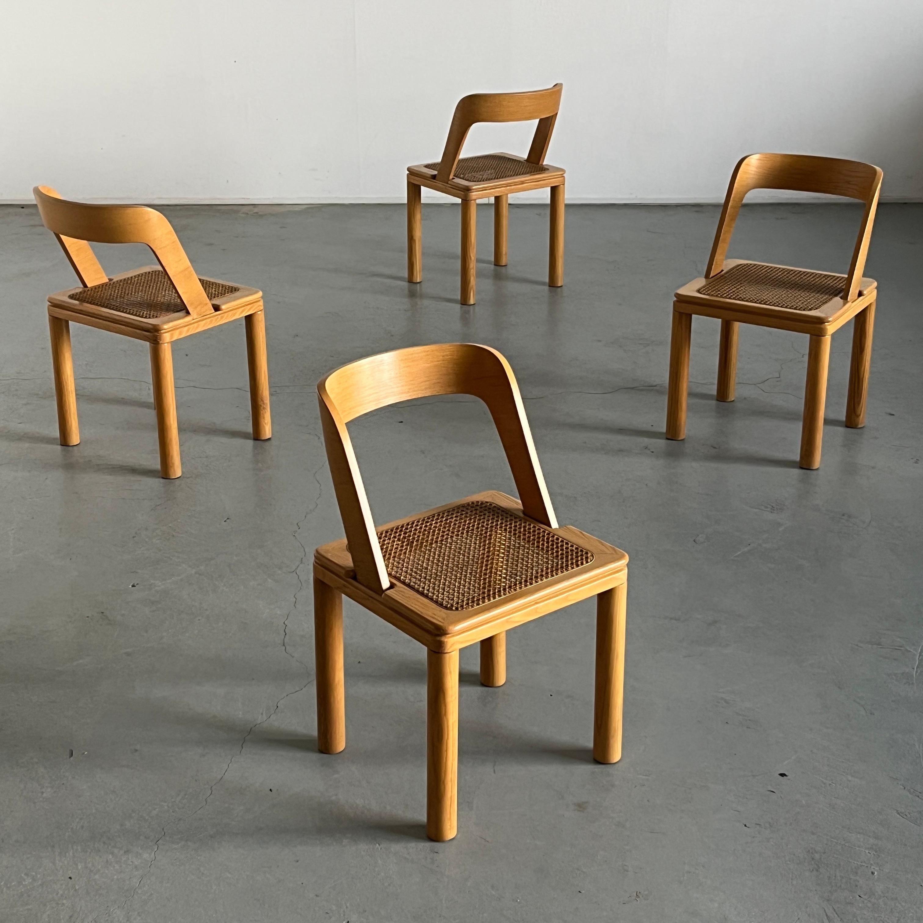 Set of four vintage Mid-century modern dining chairs by Italian manufacturer RB Rossana. Featuring a sleek diagonal curved backrest, cane seat and four cylindrical legs.
Manufactured in Bergamo, Italy in the 1960s.  

Chairs are in good condition