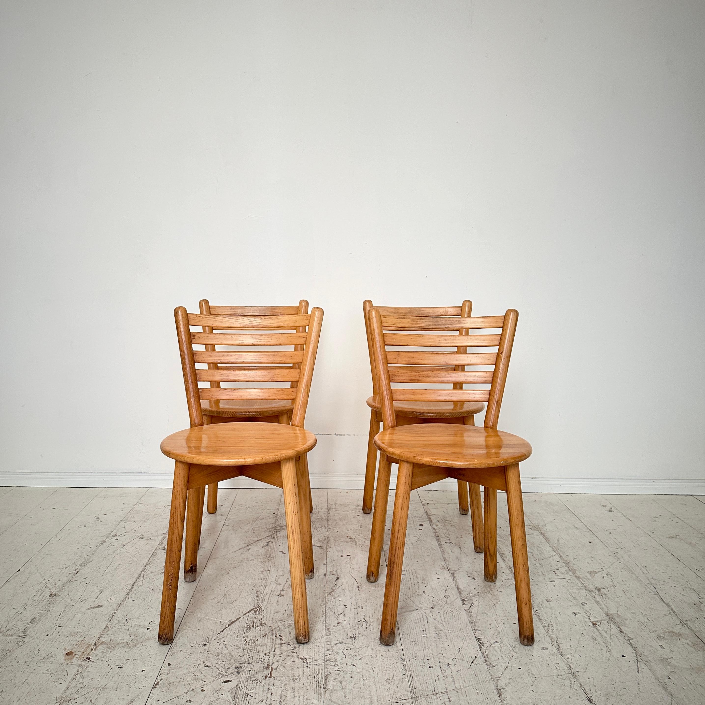 Embrace the timeless allure of mid-century Italian craftsmanship with this set of four dining chairs crafted from solid elm, circa 1960. Each chair stands as a testament to the era's commitment to both form and function, boasting clean lines and