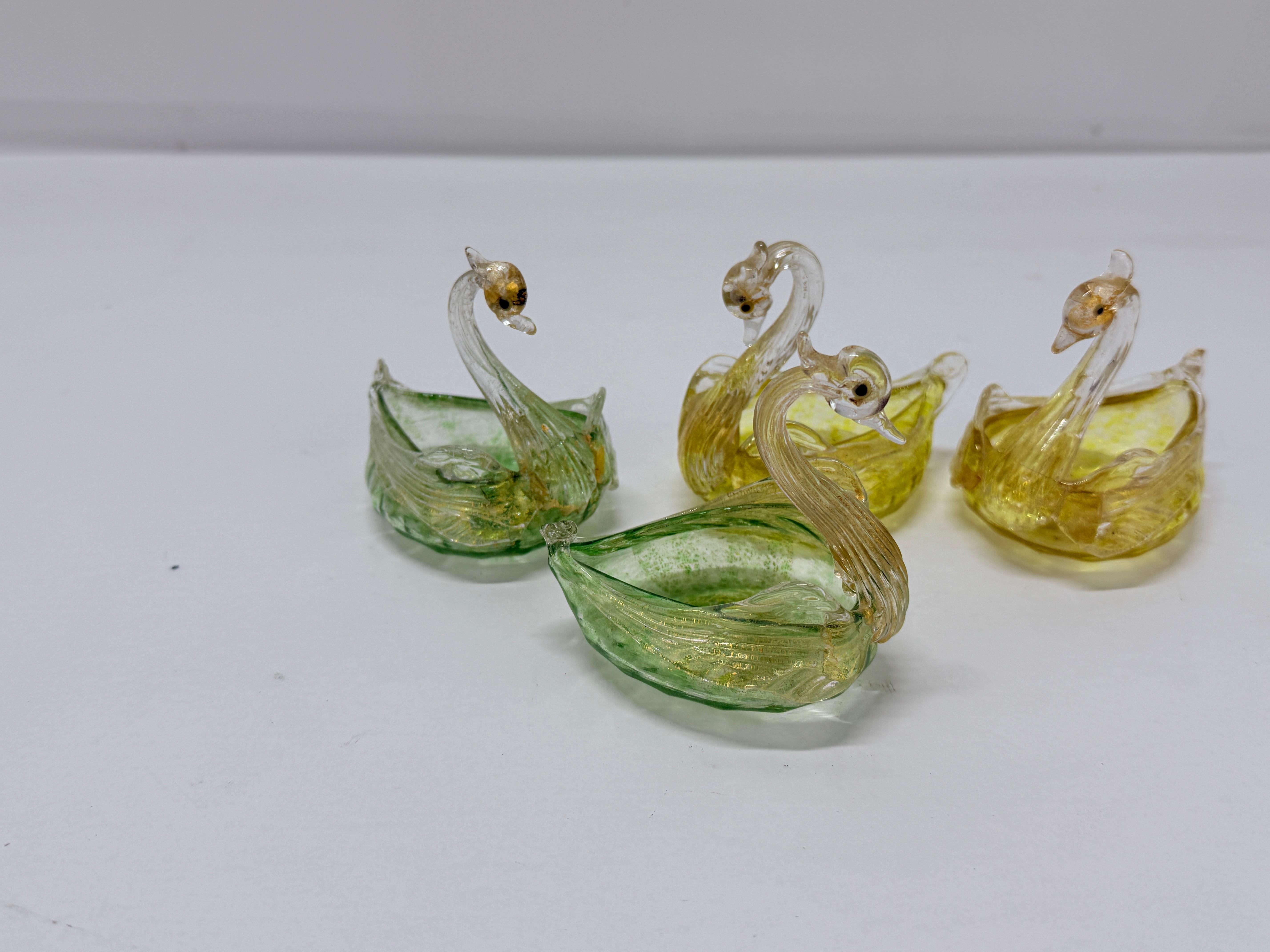 This set of four exquisite Murano glass salt cellars captures the timeless elegance and craftsmanship of mid-century Italian glassmaking. Each cellar is delicately shaped in the form of a swan, with gracefully arched necks and intricately detailed