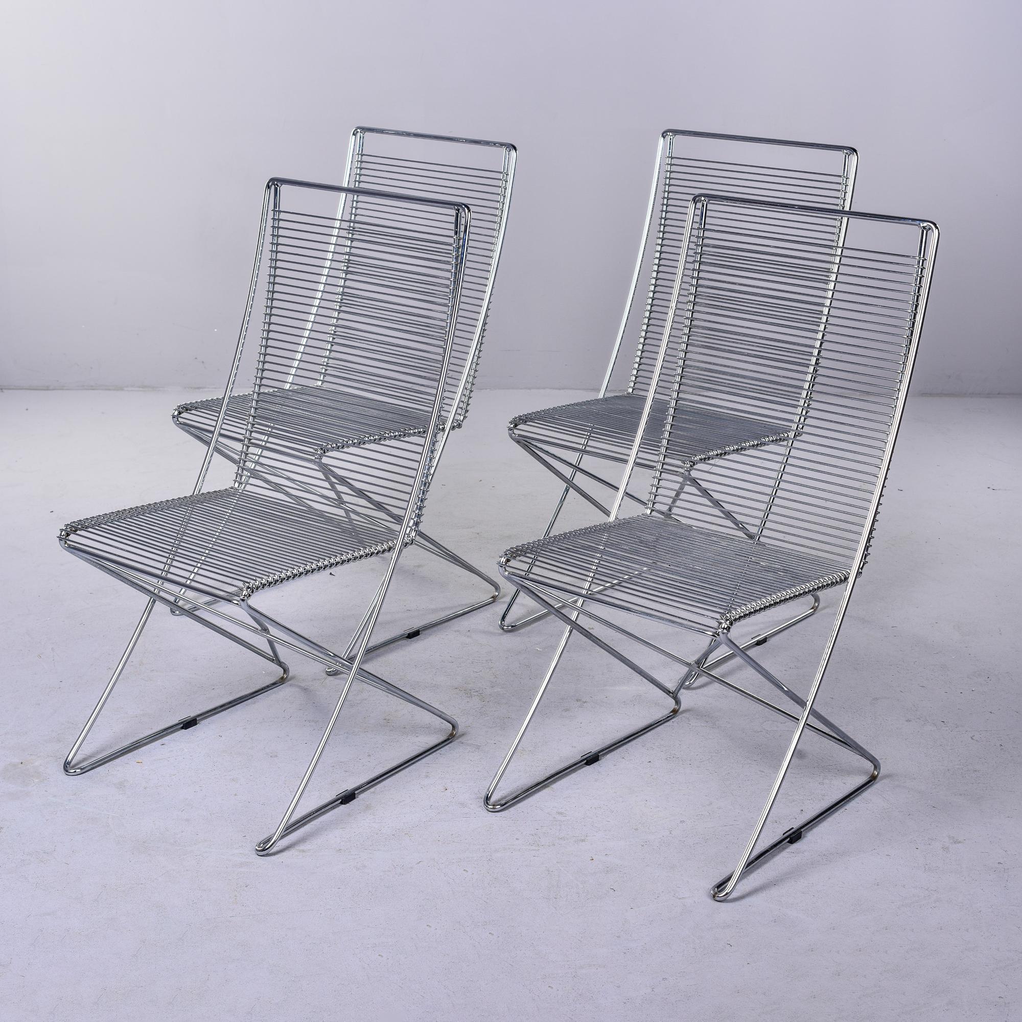 Circa 1980s set of four German Kreuzschwinger chairs designed by Till Behrens for Schlubach. These chairs are made entirely of bent and welded steel bars. The unique classic design is surprisingly comfortable and the dynamics of the chair allow it
