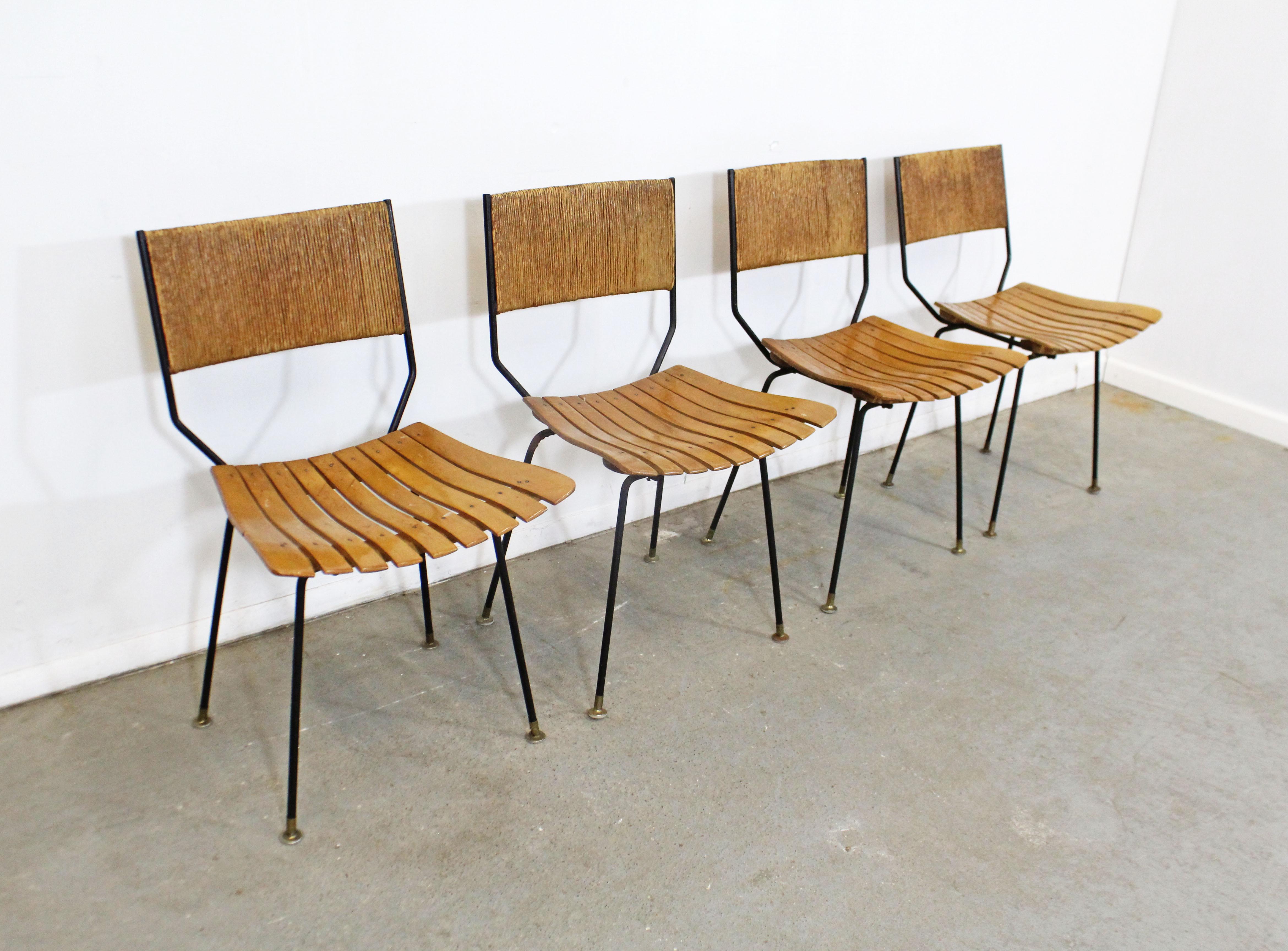 Offered is a set of 4 vintage Mid-Century Modern dining chairs attributed to Arthur Umanoff for Raymor. These chairs have slat-wood seats and rush-backs with metal bases. They are in decent, structurally sound condition for their age, showing some