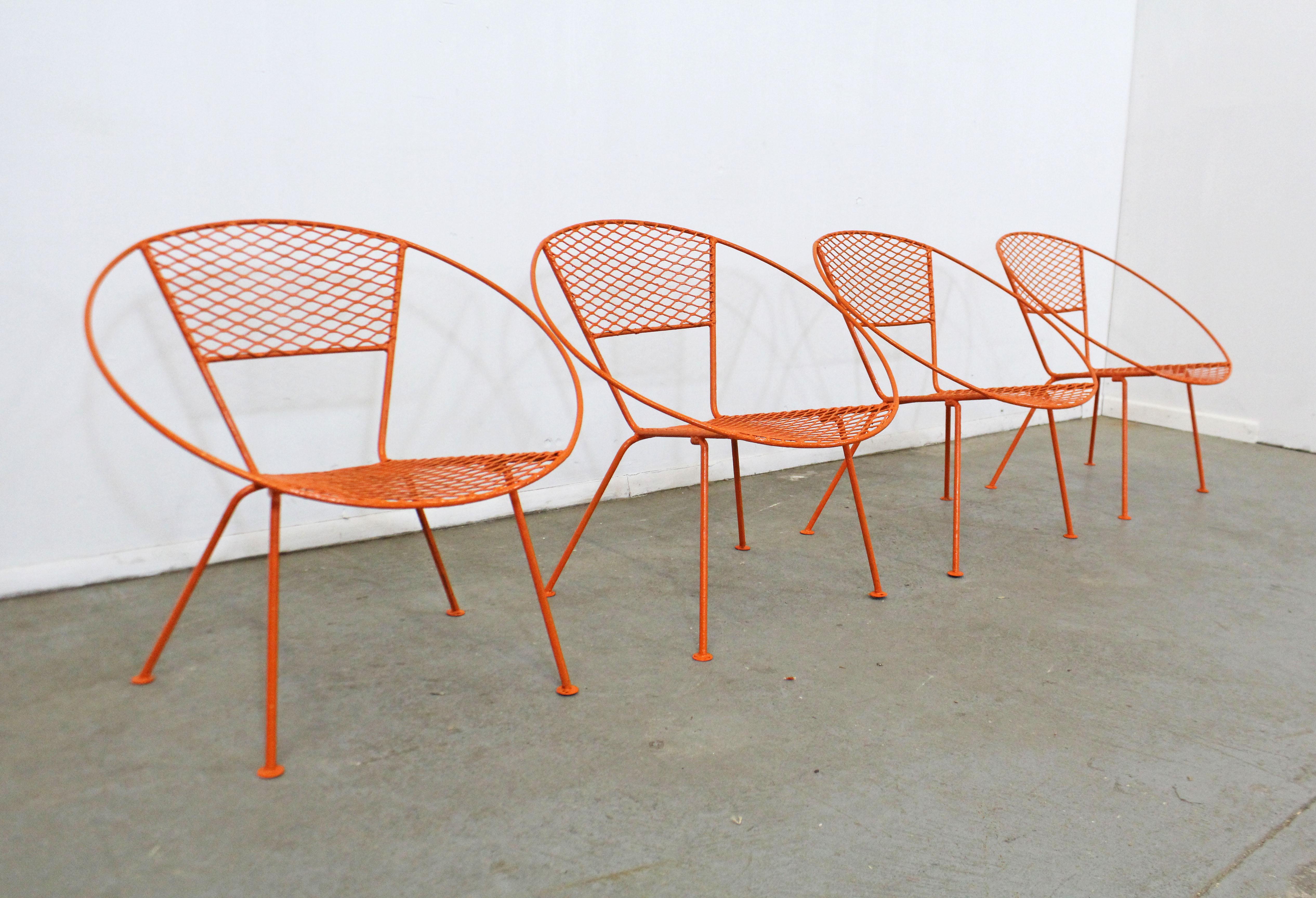 What a find. Offered is a set of 4 vintage Mid-Century Modern outdoor circle chairs. Includes four metal chairs with hoop mesh backs and seats that have been painted orange. The chairs are in good condition with minor surface wear and orange paint.