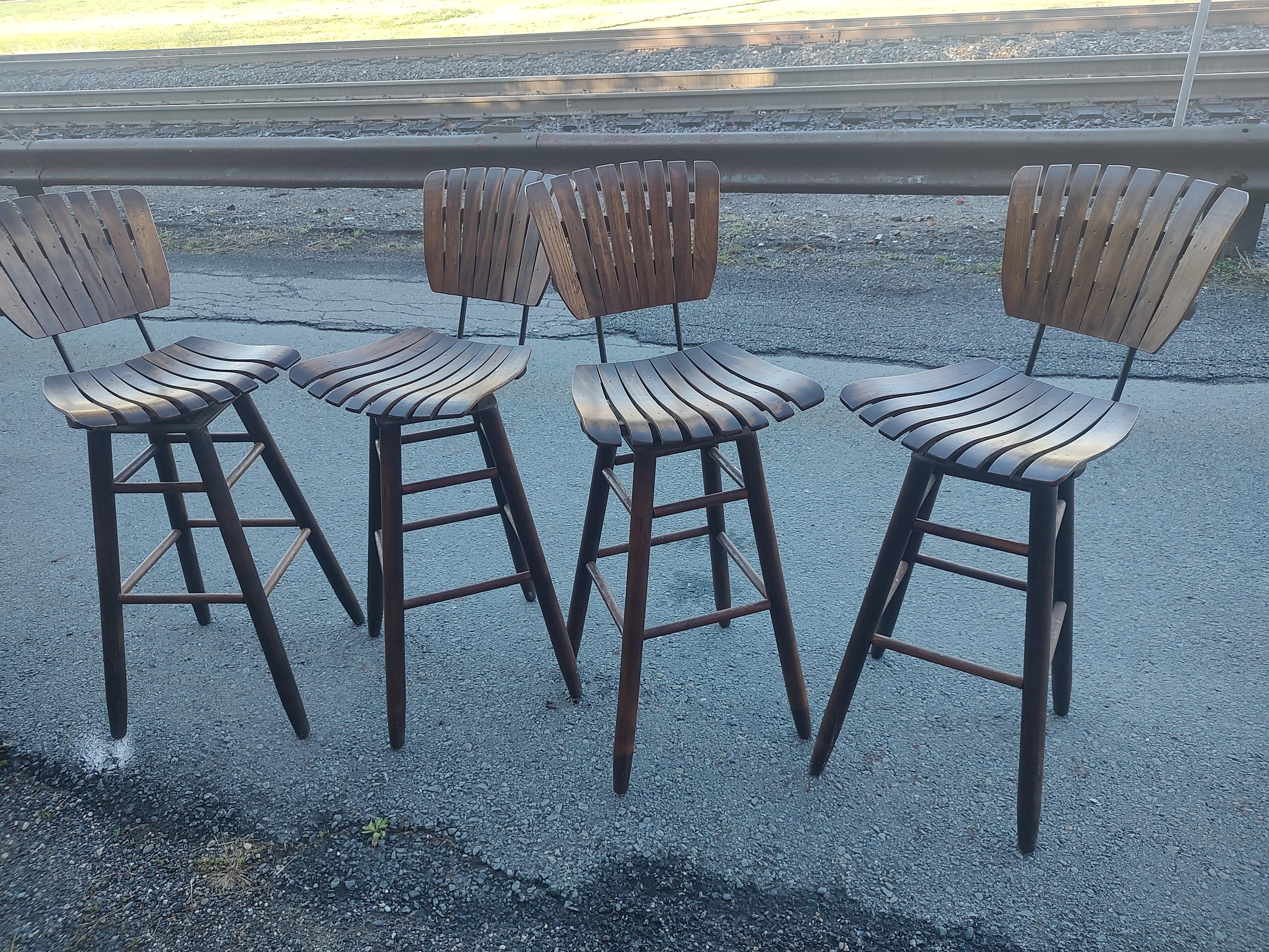 Set of four wood Slatted bar/counter stools with a seat height of 30 inch. All hardwood with iron connectors brackets for support. Will sell as pairs or all four together. In excellent vintage condition with minimal wear. All swivel. Priced