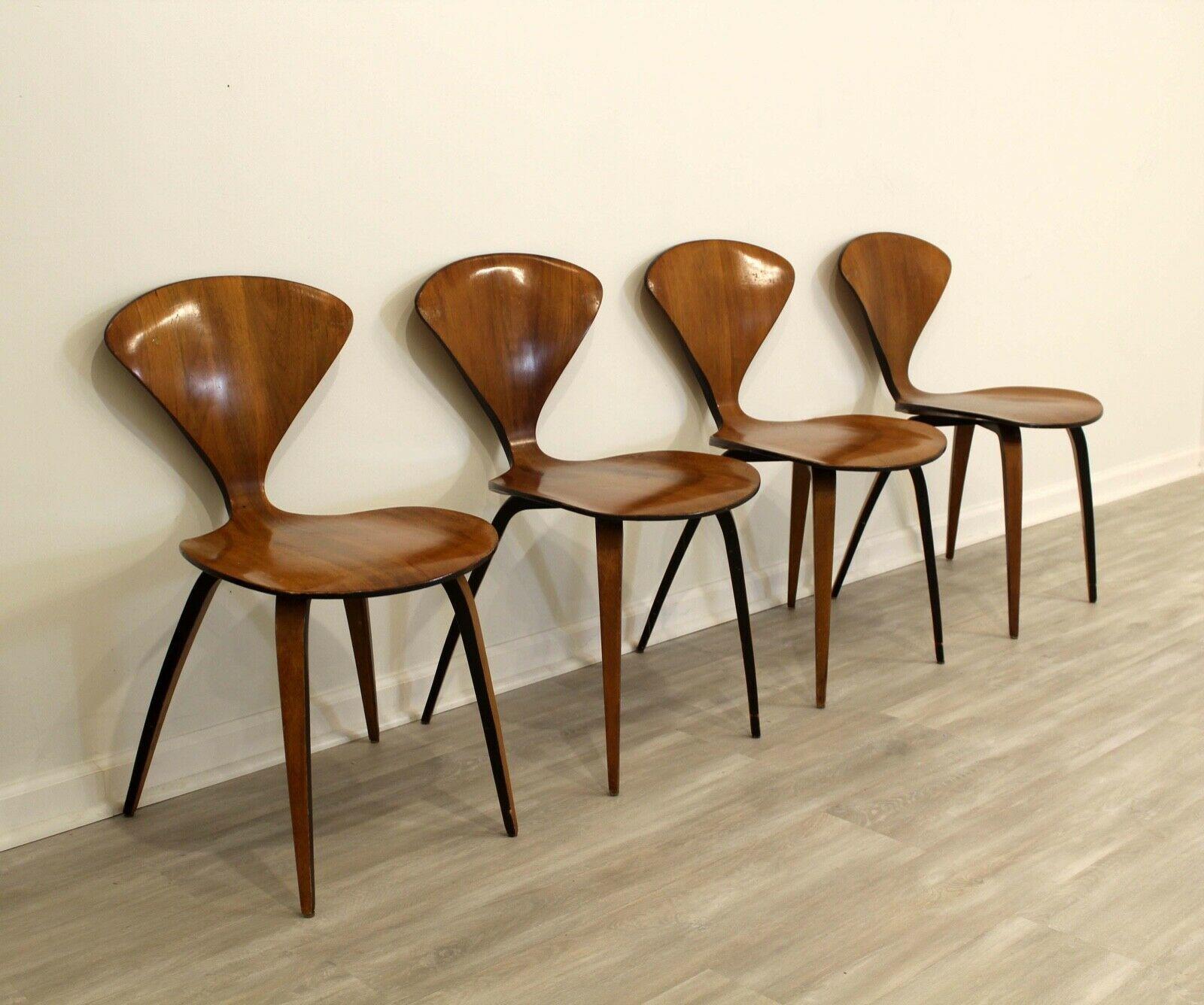 This set of four 1950's Modern-style side chairs are designed by Bernardo for Plycraft Inc. The chairs are made from molded bent plywood with the original walnut stain with black accents on the edges and a polished finish. The chars have a triangle