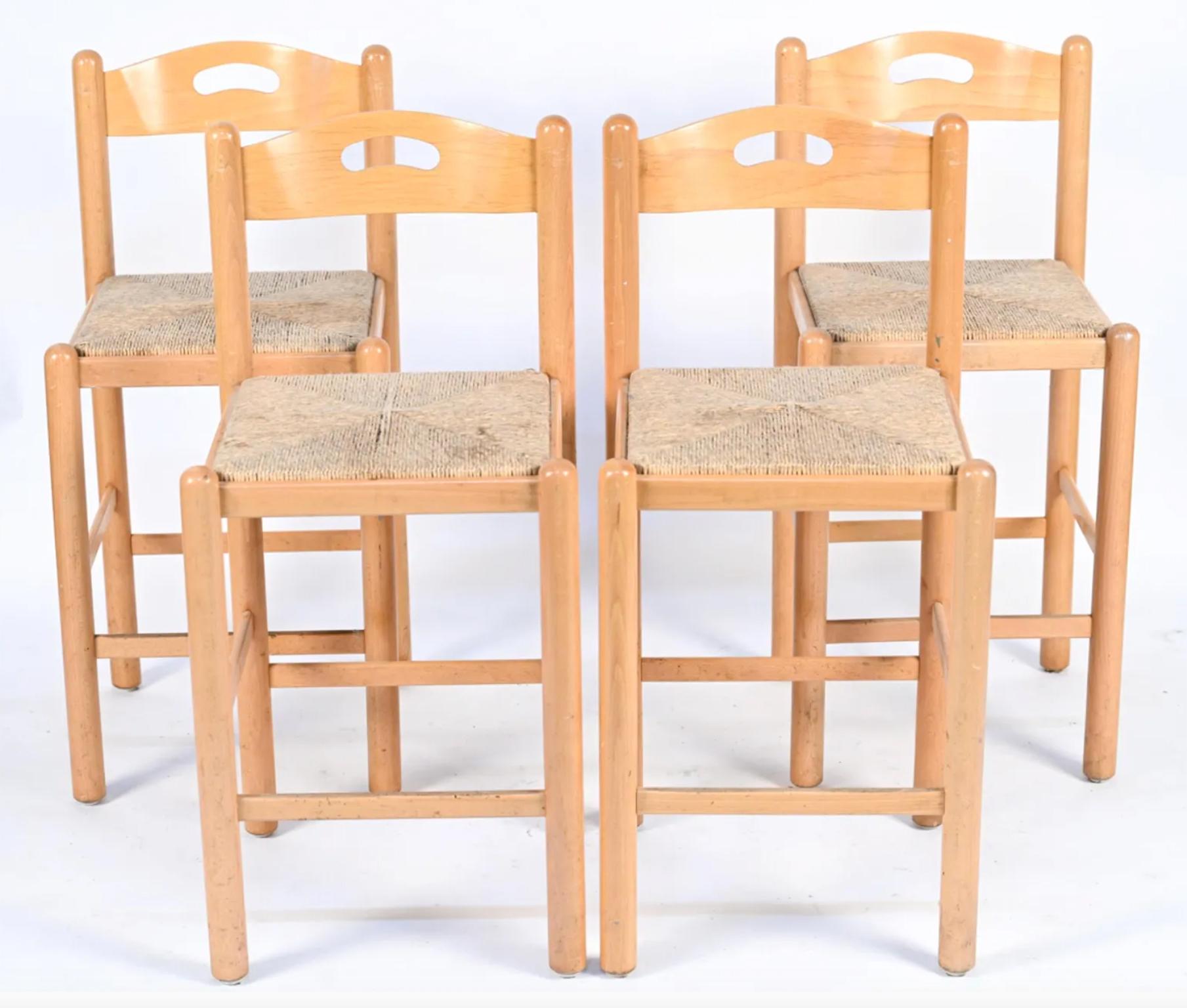 Set of 4 Mid-Century Modern bar stools style of Vico Magistretti. Circular Birch framed and rush woven seats with bent plywood back rests. 24” seat height. Solid sturdy stools in good vintage condition. This listing is for the set of 4 stools.