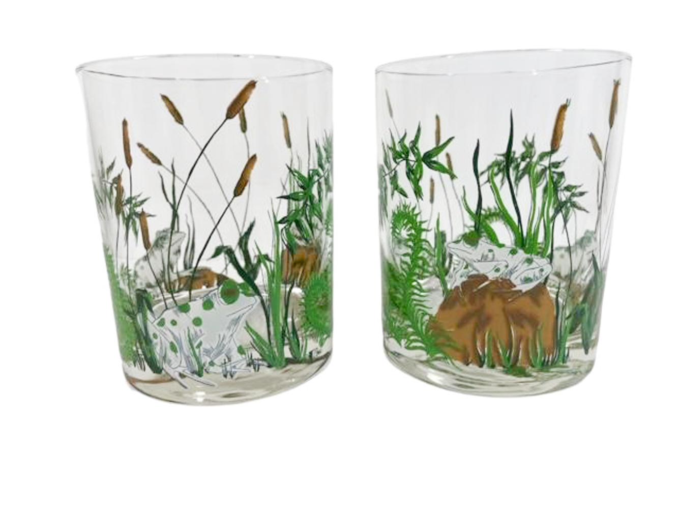 Set of four rocks glasses by Cera Glassware with frogs sitting on rocks among ferns and cattails.