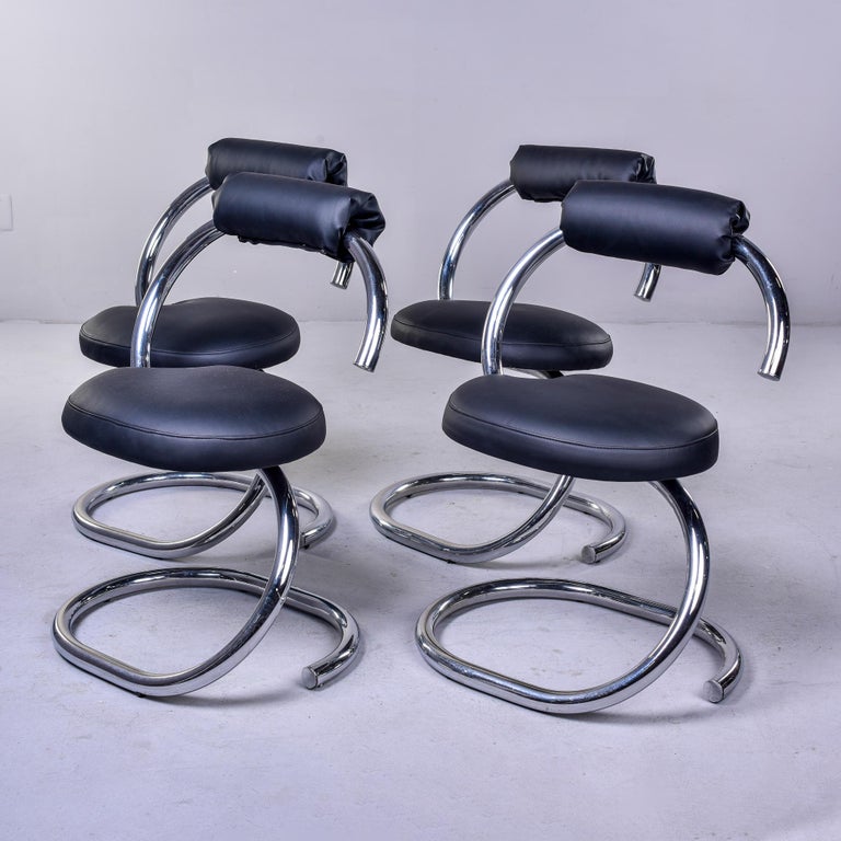 Found in France, this set of four circa 1970s chrome chairs feature distinctive open spiral-type chrome frames and black faux leather seats and back rests. Unknown maker. Sold and priced as a set of four.