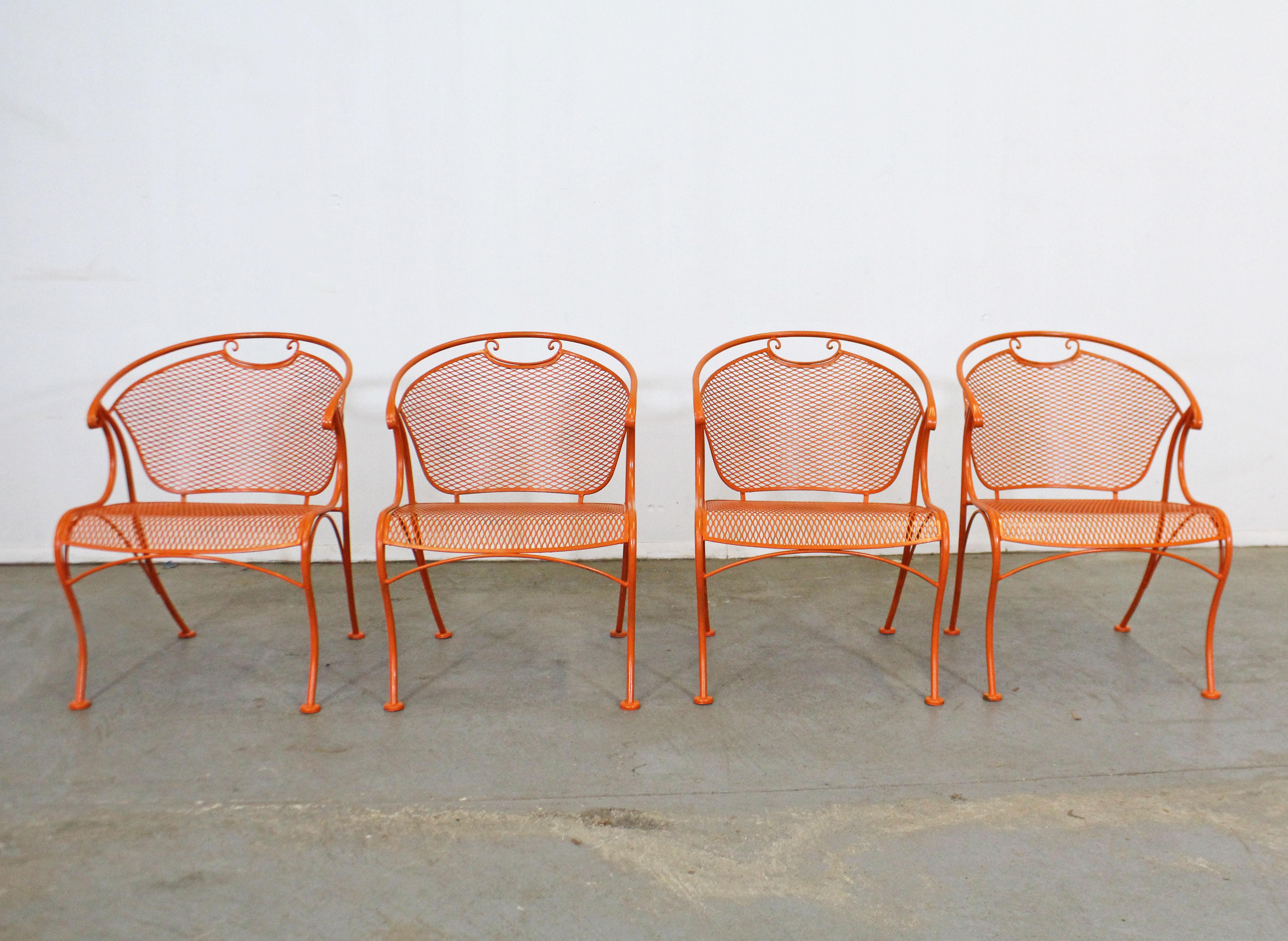 What a find. Offered is a set of 4 vintage iron outdoor armchairs with mesh seats and backs and uniquely curved legs and arms. The chairs are structurally sound, in very good condition and have been repainted orange. They are not